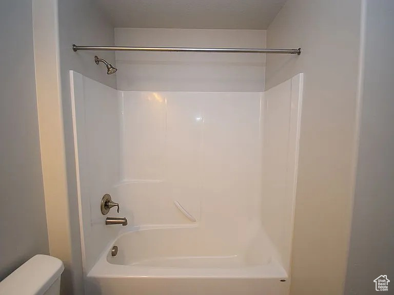 Bathroom featuring toilet and shower / washtub combination