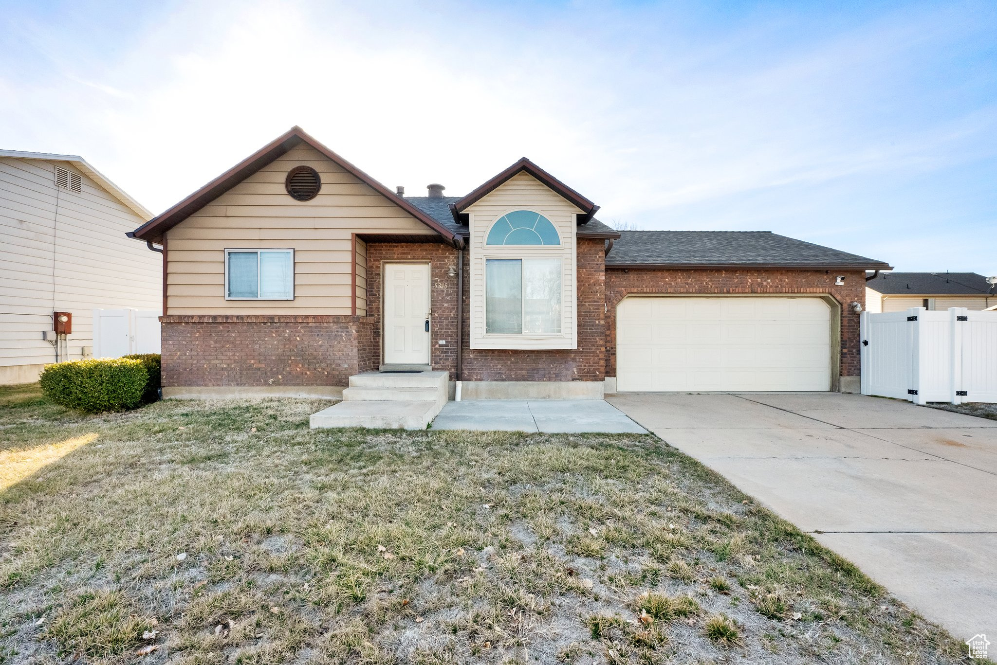 Single story home with brick siding, fence, concrete driveway, a front yard, and an attached garage