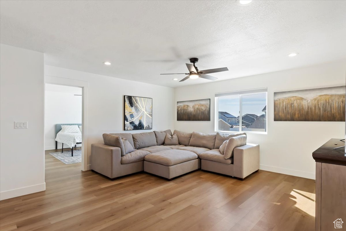 Living room with recessed lighting, light wood-style floors, baseboards, and ceiling fan