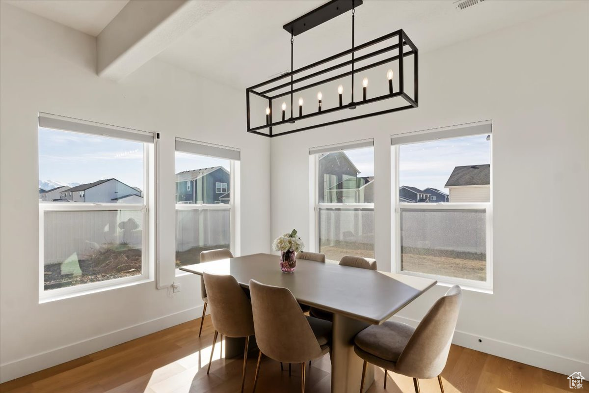 Dining space featuring a wealth of natural light, baseboards, and wood finished floors