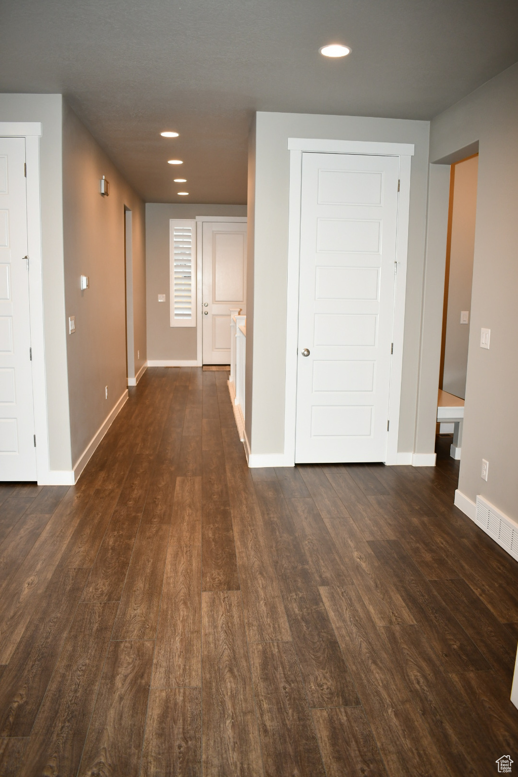 Corridor with visible vents, baseboards, dark wood finished floors, and recessed lighting