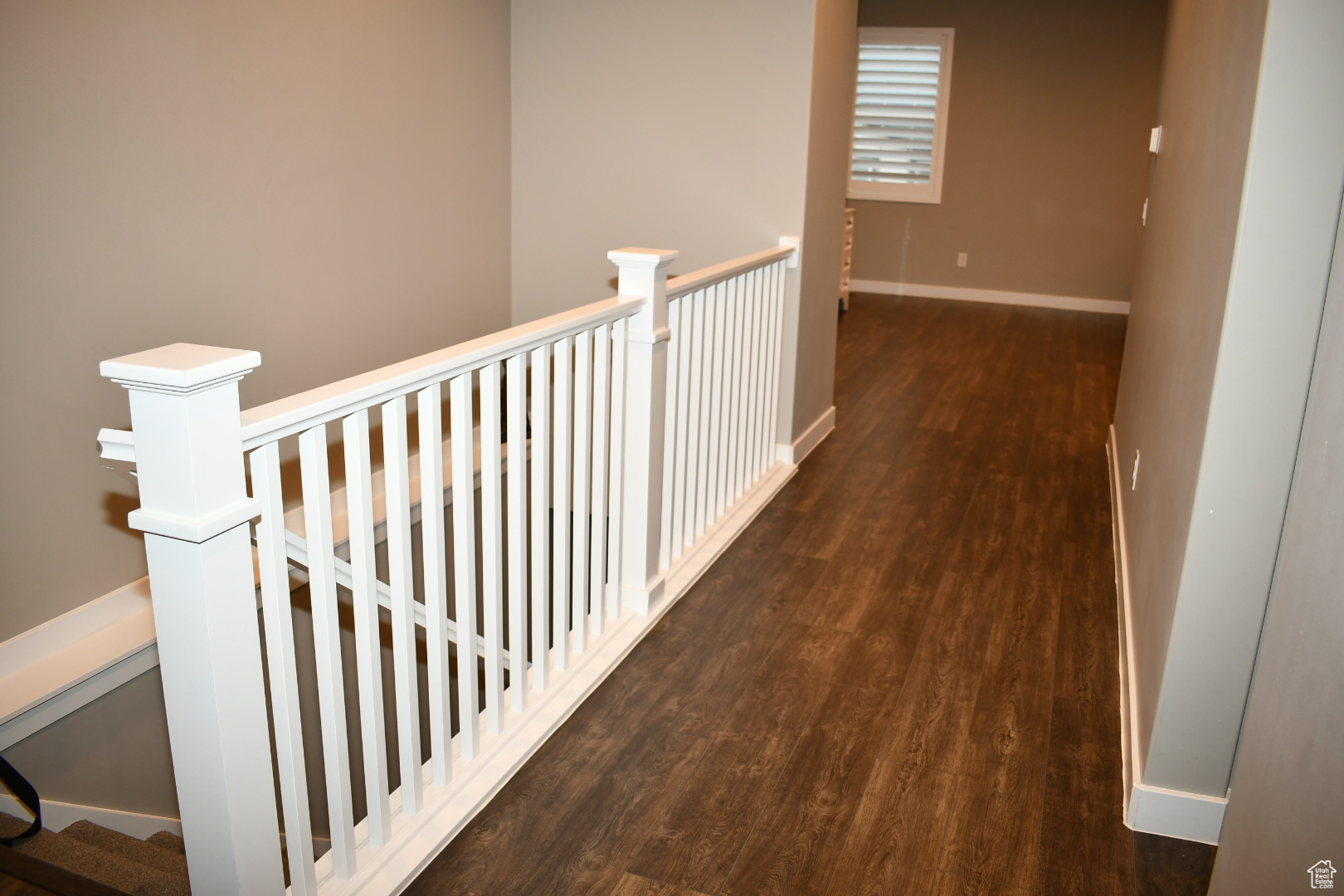 Hallway with baseboards and wood finished floors