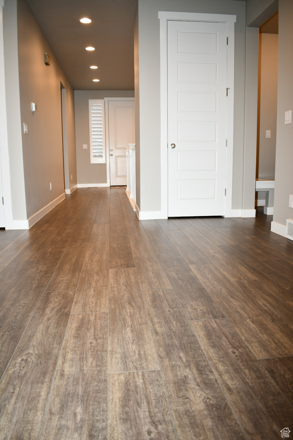 Empty room featuring dark wood-style flooring, recessed lighting, and baseboards