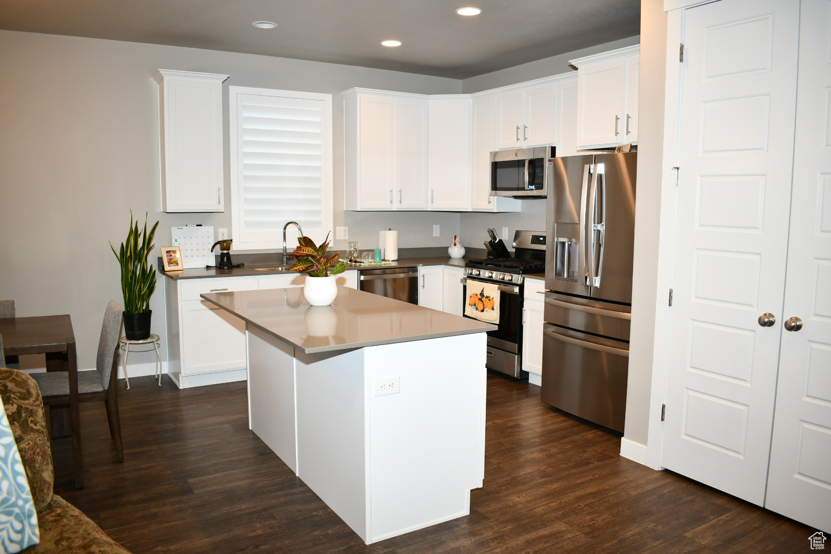 Kitchen featuring white cabinets, appliances with stainless steel finishes, dark wood finished floors, and recessed lighting