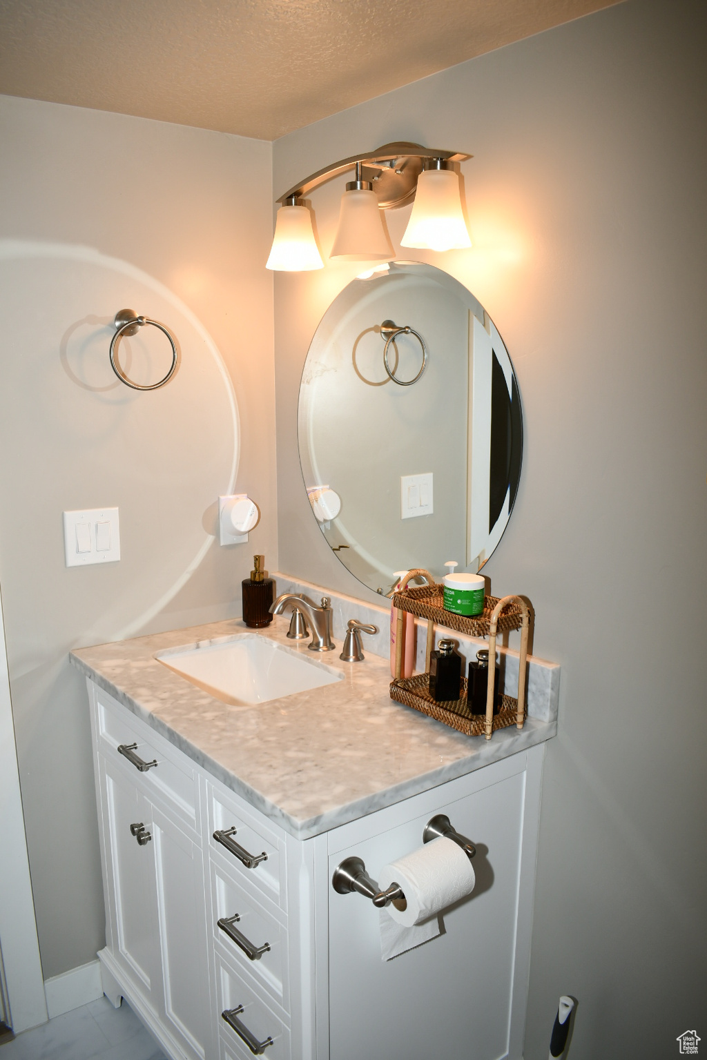 Bathroom with baseboards, vanity, and a textured ceiling