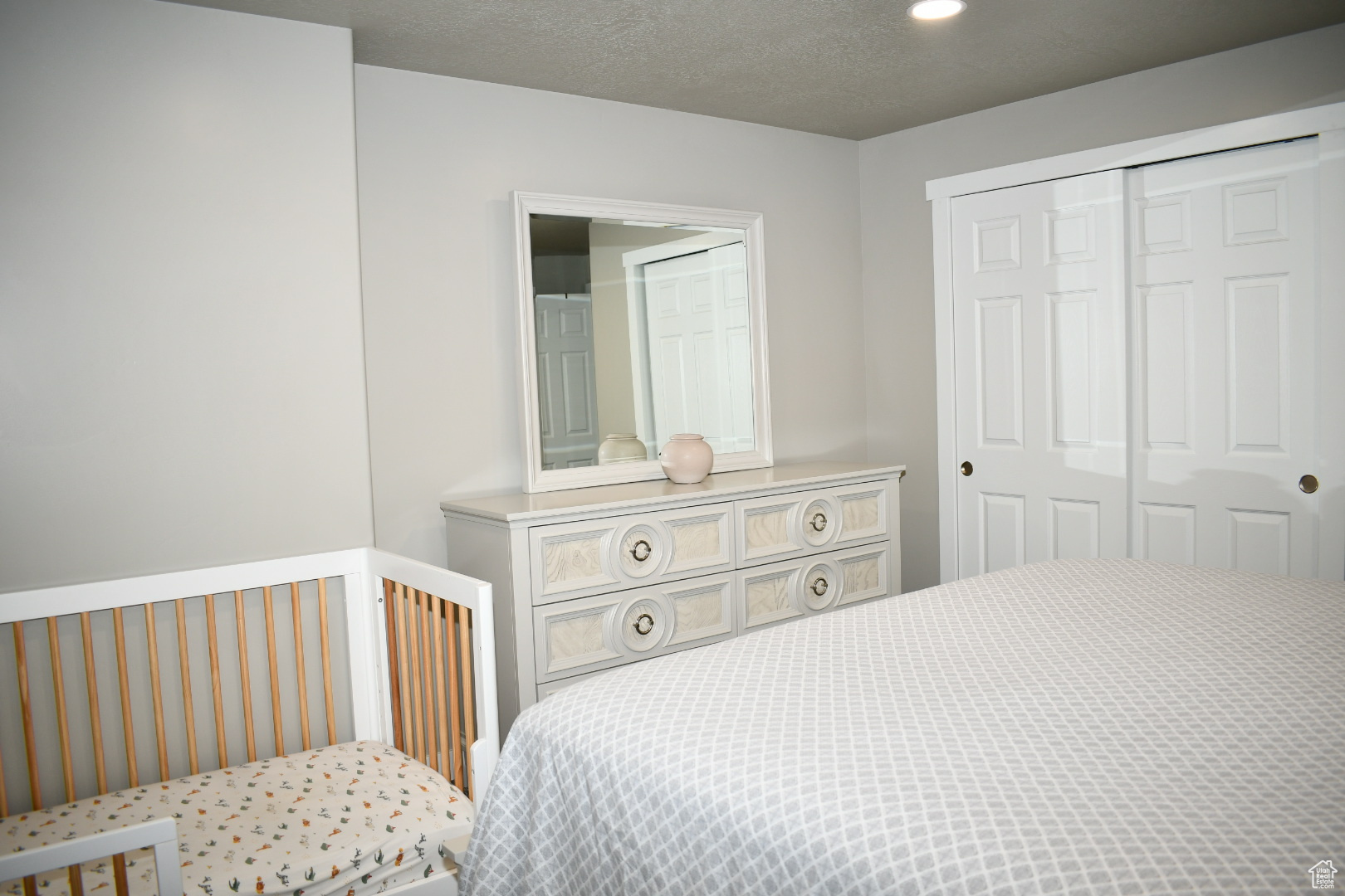 Bedroom with a textured ceiling, a closet, and recessed lighting