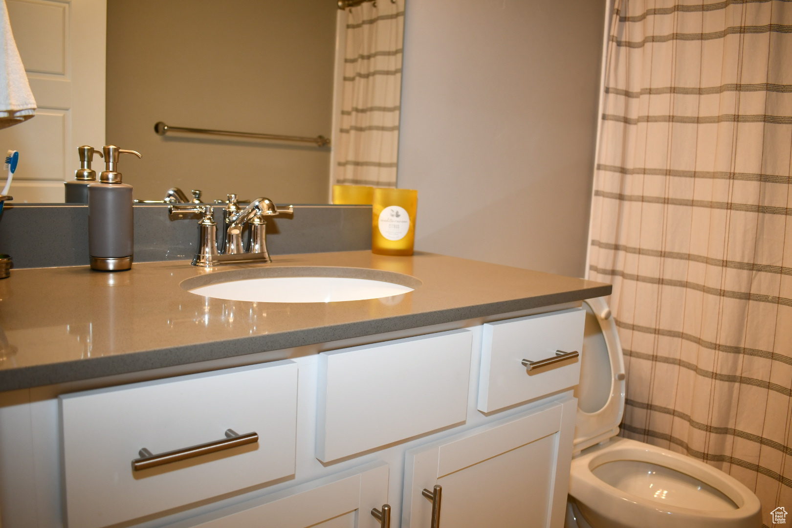 Full bathroom with toilet, a shower with curtain, and vanity