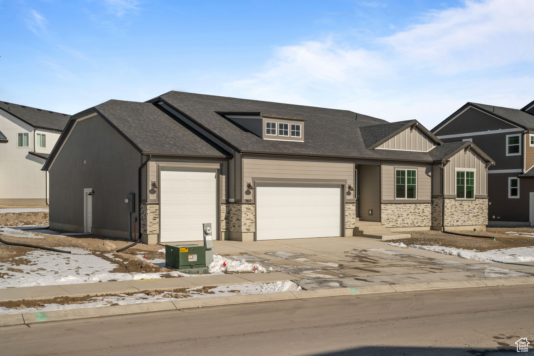 View of front of property featuring board and batten siding, a garage, driveway, and roof with shingles