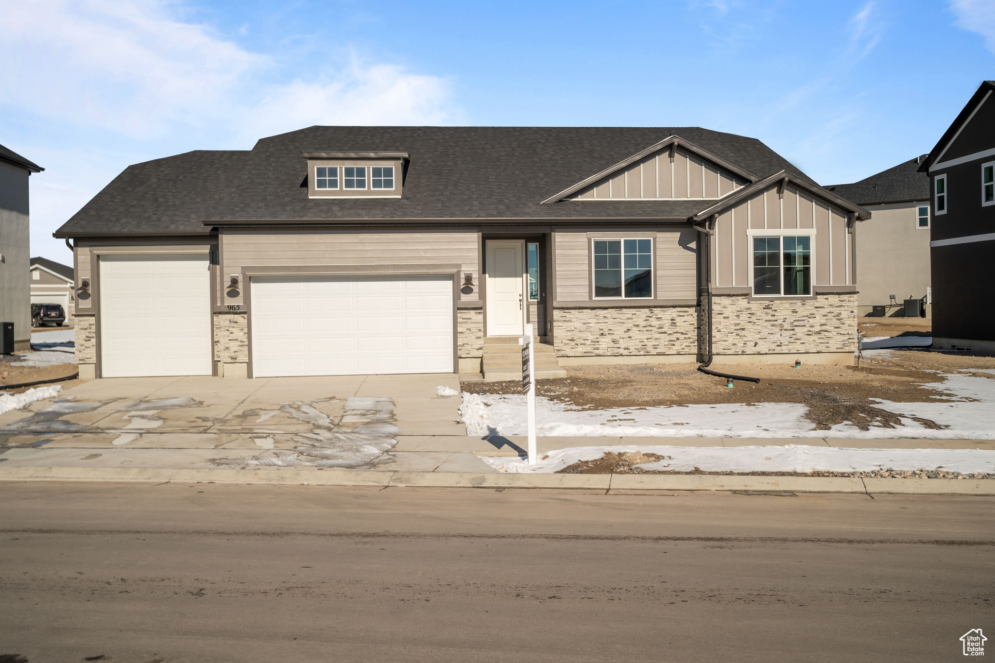 View of front of house with board and batten siding, concrete driveway, a garage, and roof with shingles