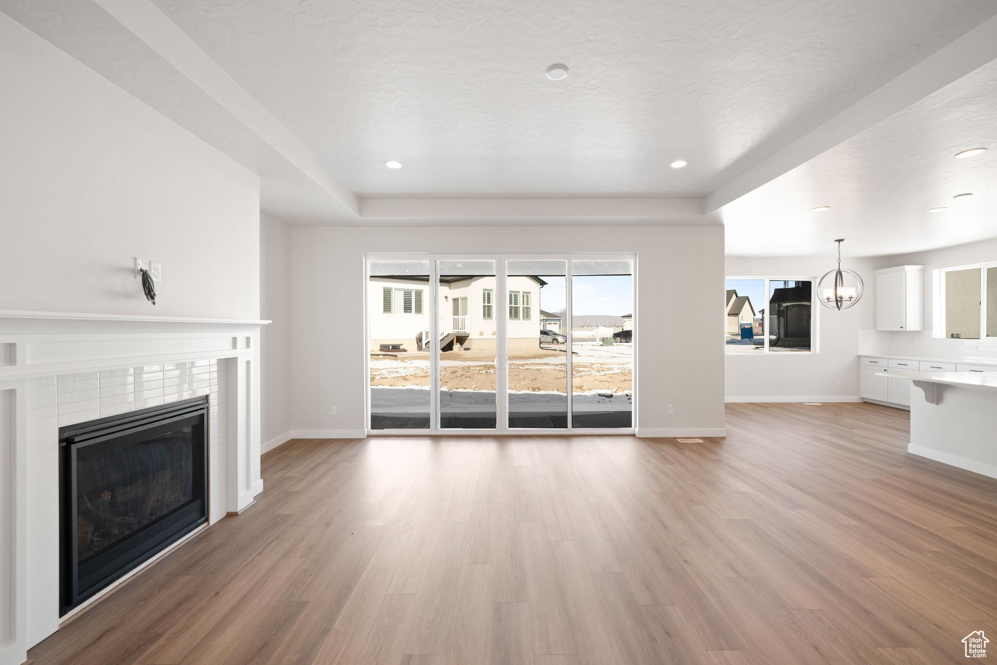 Unfurnished living room with recessed lighting, light wood-style flooring, a tile fireplace, and baseboards