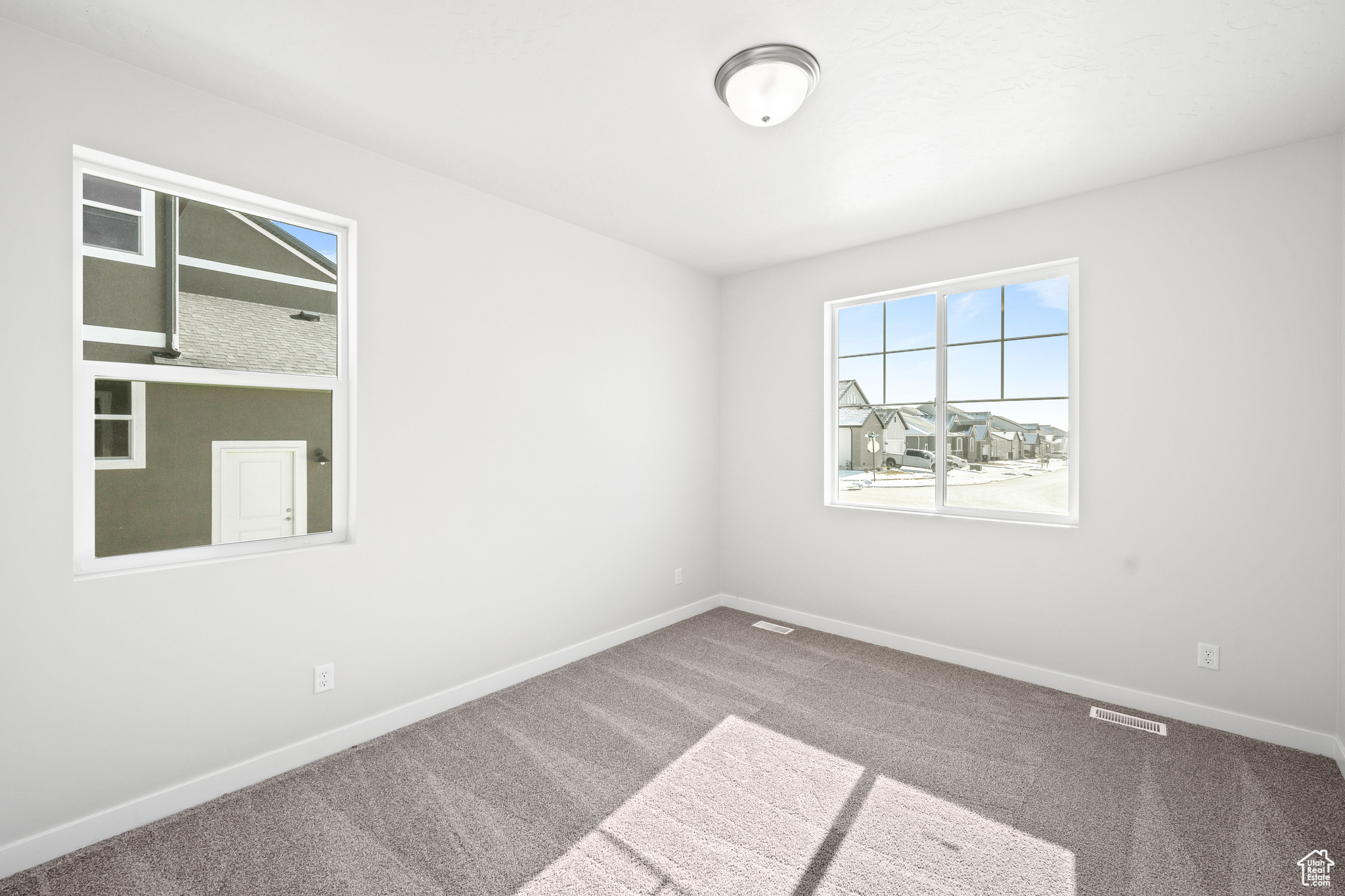 Spare room featuring visible vents, baseboards, and carpet