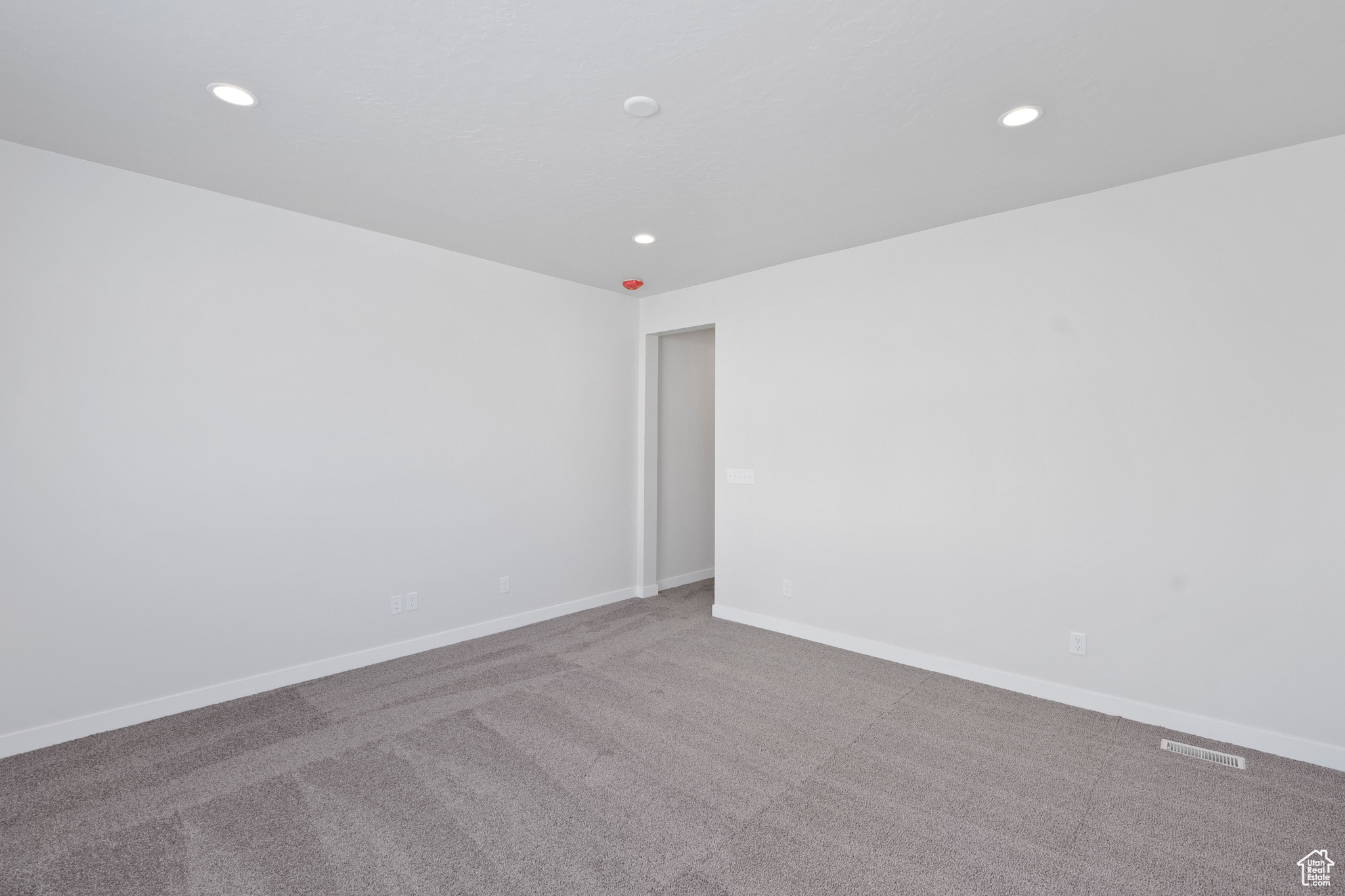Carpeted spare room featuring recessed lighting and baseboards