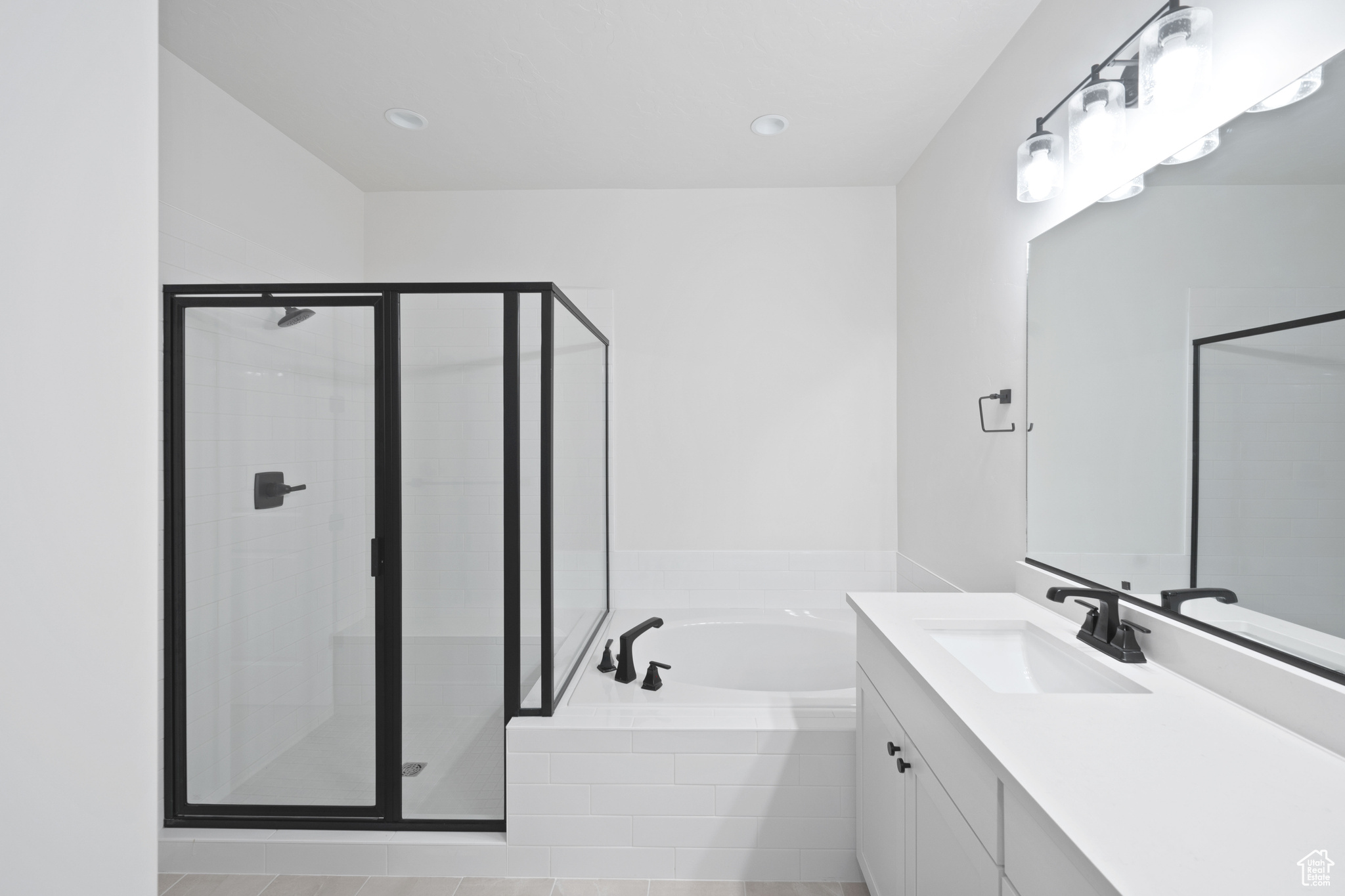 Full bath with a stall shower, vanity, and a garden tub