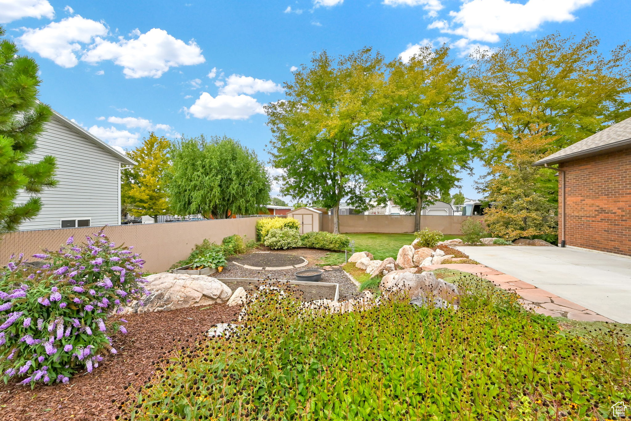 View of yard featuring a storage shed, a fenced backyard, an outbuilding, and a patio