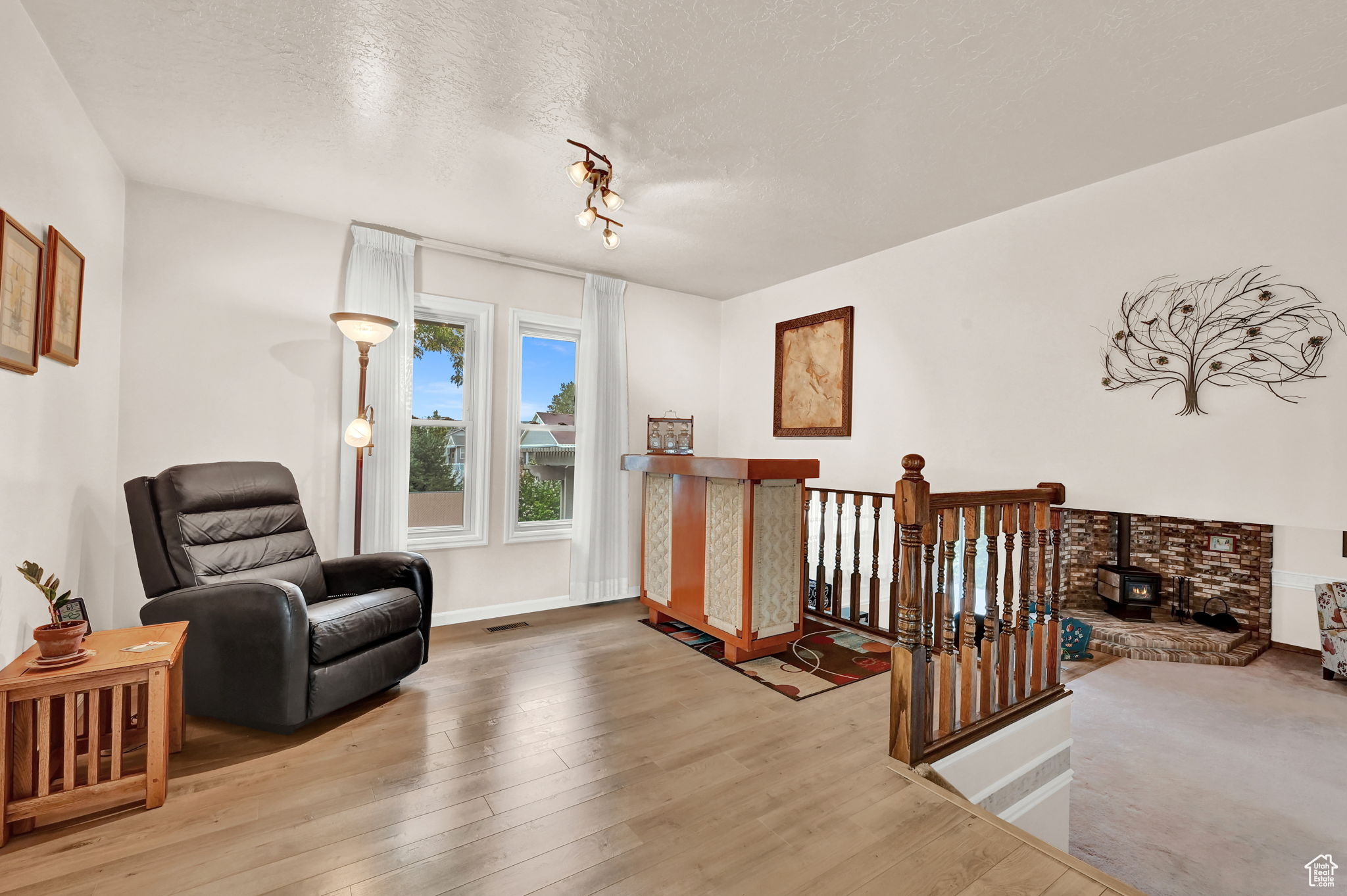 Living area featuring visible vents, baseboards, a textured ceiling, and hardwood / wood-style floors