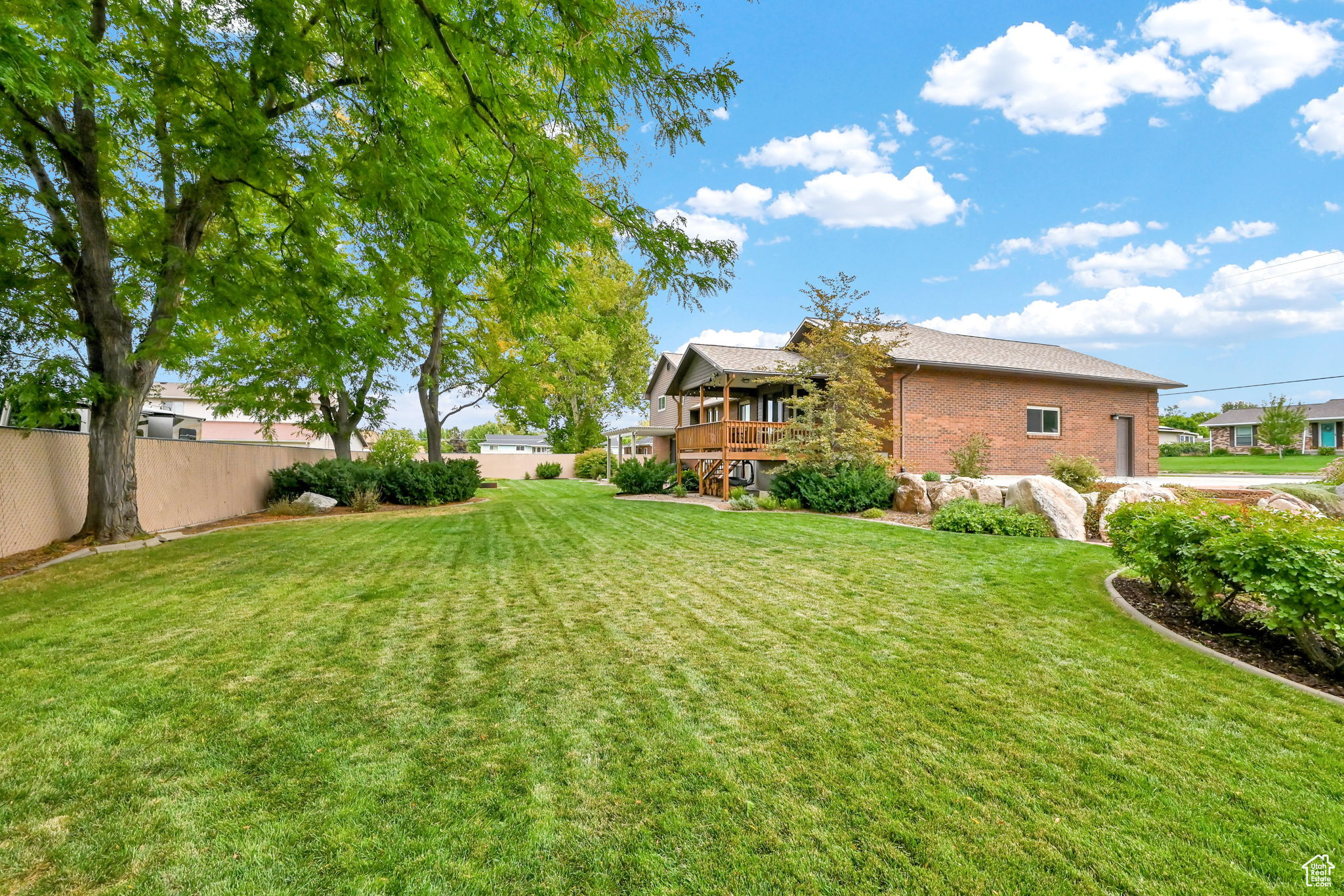 View of yard with a wooden deck and fence