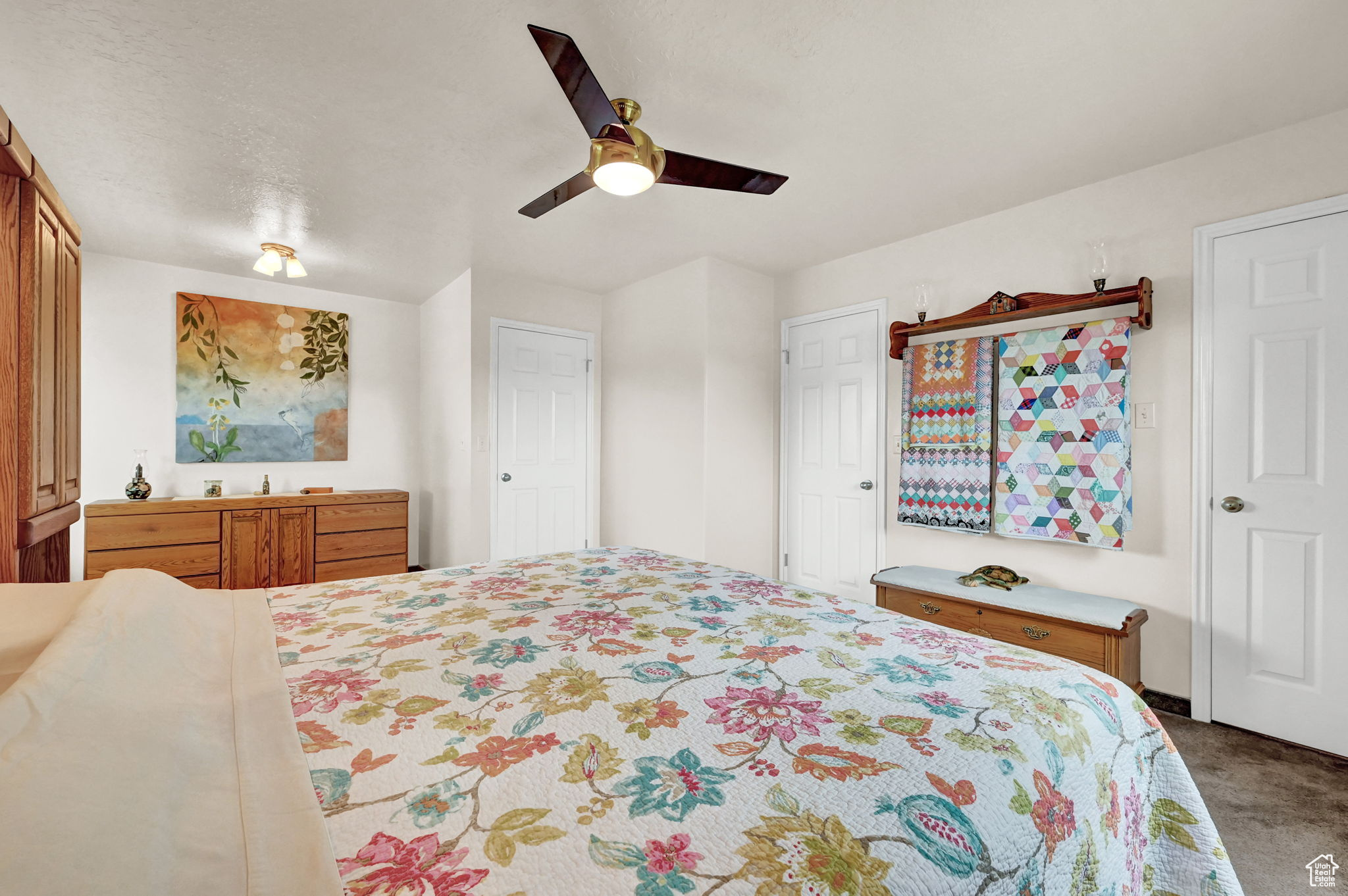 Carpeted bedroom with a ceiling fan