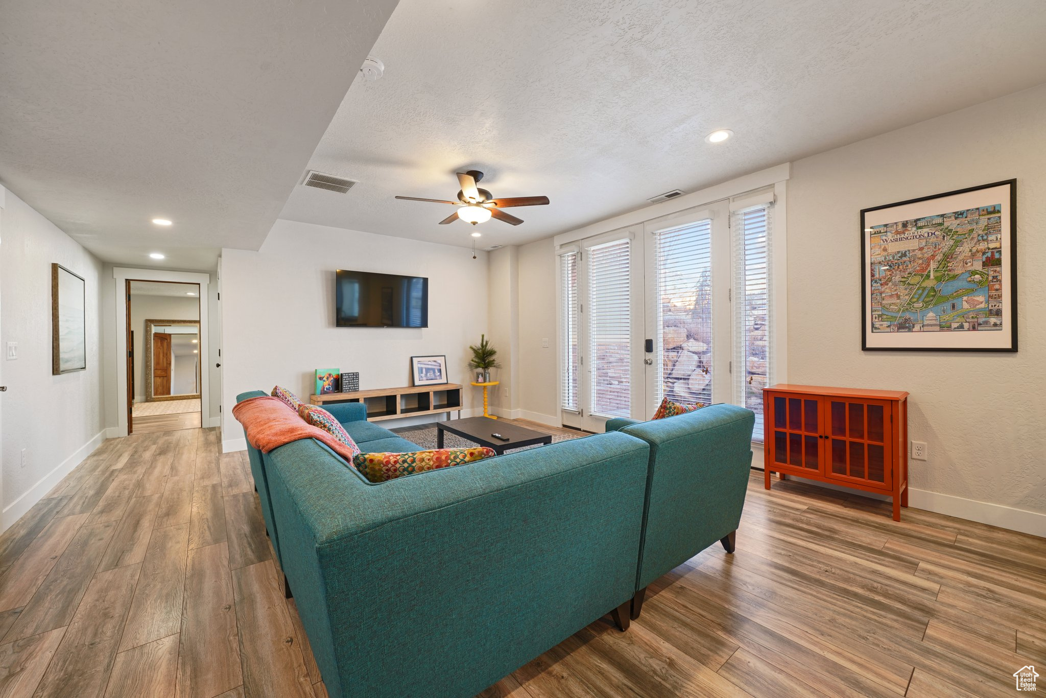 Living room featuring visible vents, a textured ceiling, wood finished floors, recessed lighting, and baseboards