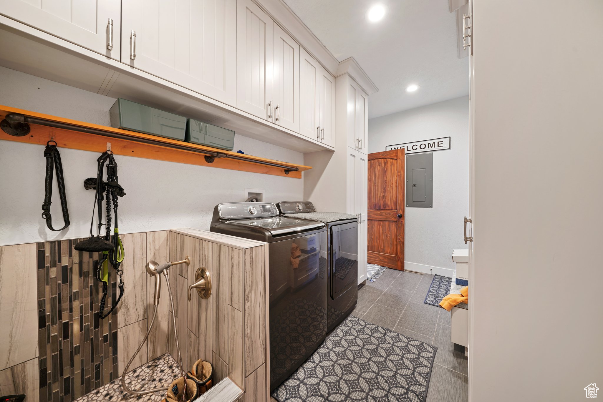 Washroom featuring electric panel, recessed lighting, washing machine and dryer, and baseboards