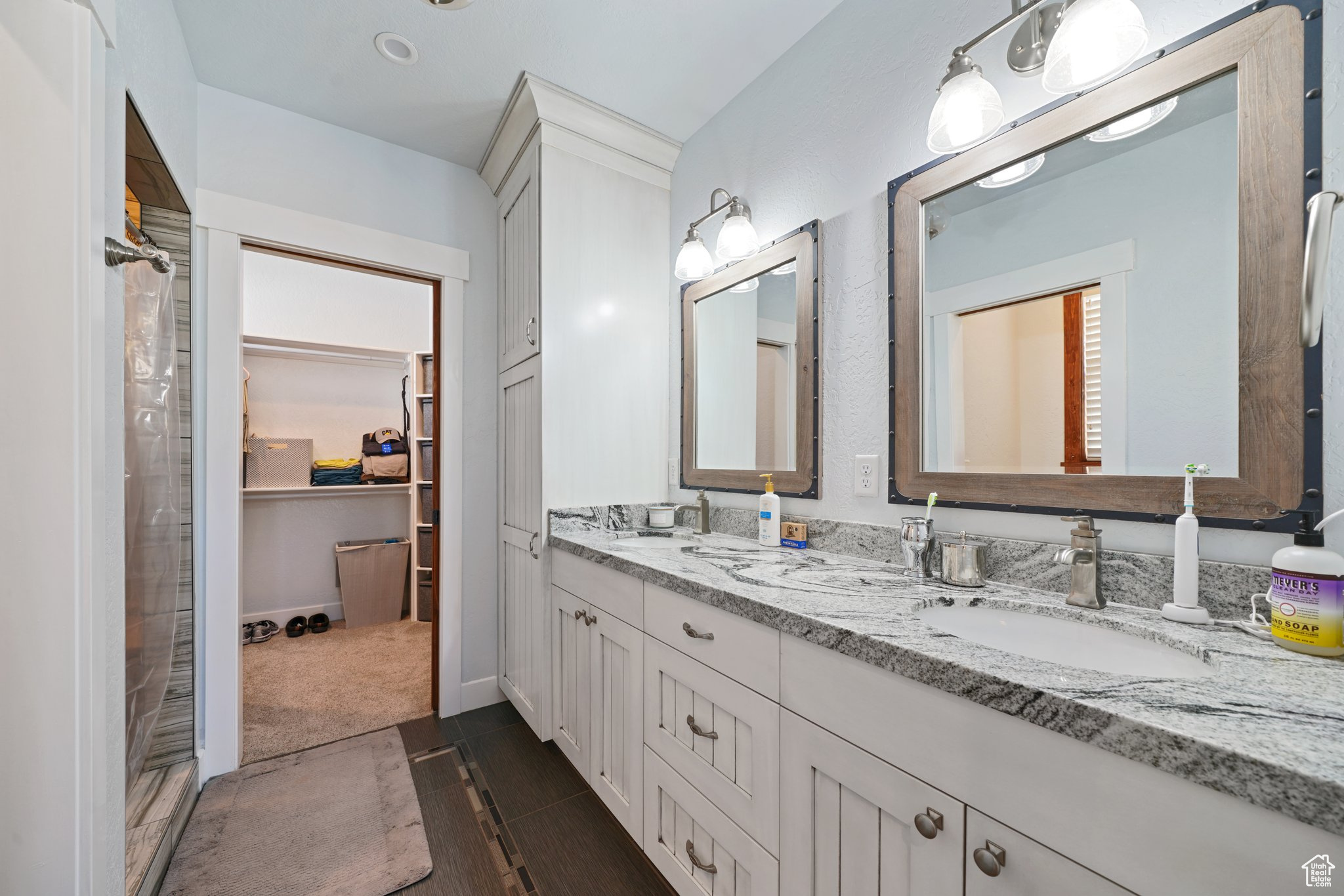 Full bath with a sink, a walk in closet, and double vanity