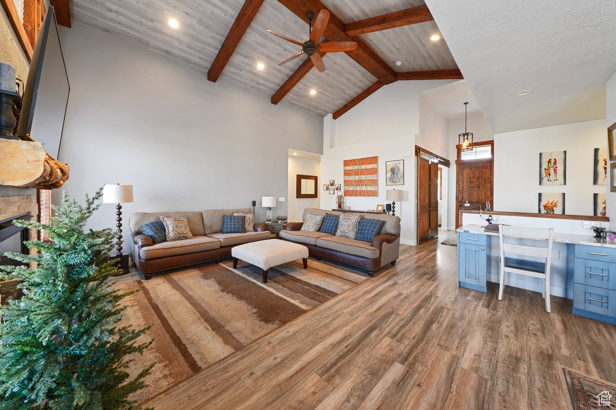 Living area with beamed ceiling, wood ceiling, a fireplace, wood finished floors, and high vaulted ceiling