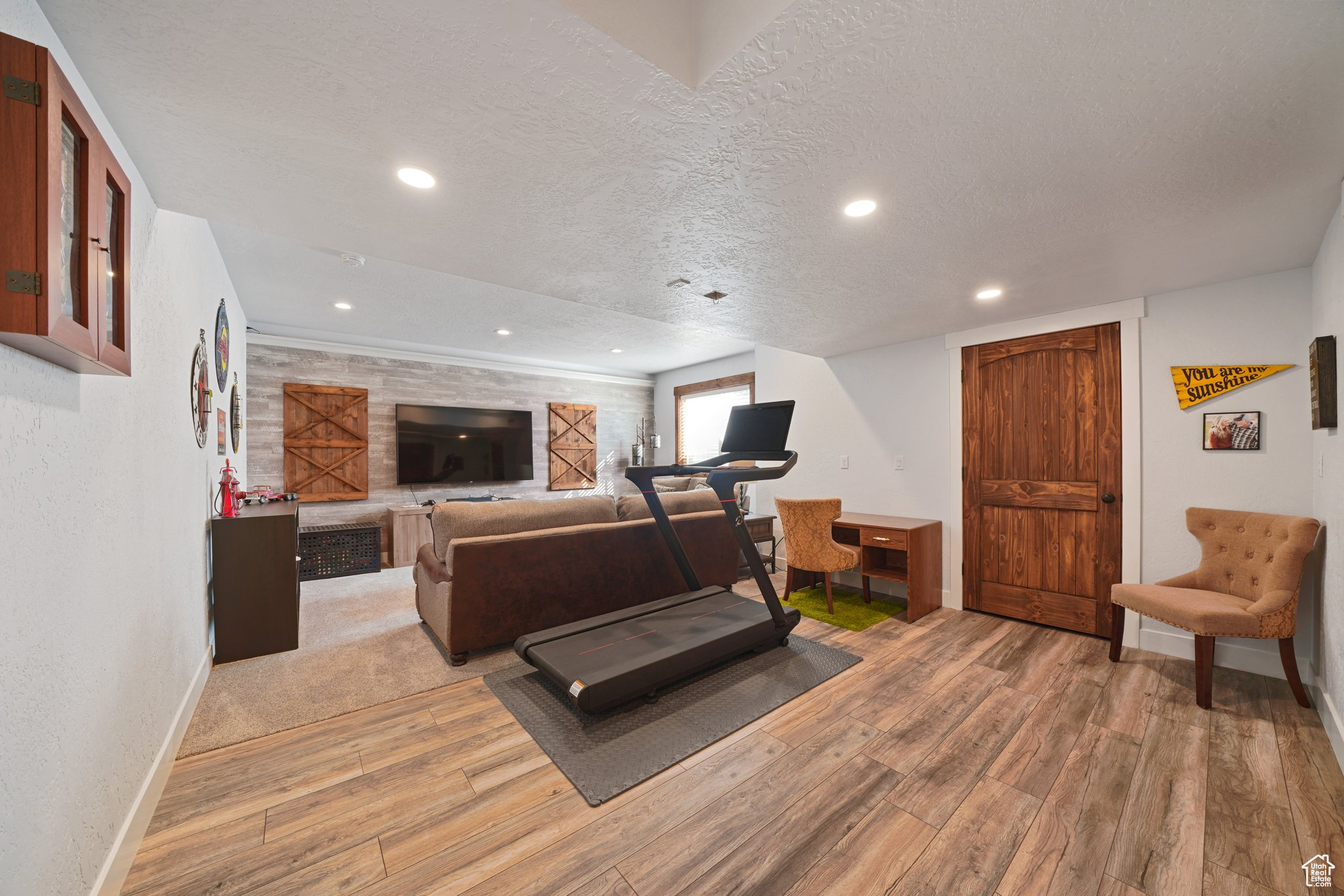 Workout room with recessed lighting, wood finished floors, baseboards, and a textured ceiling