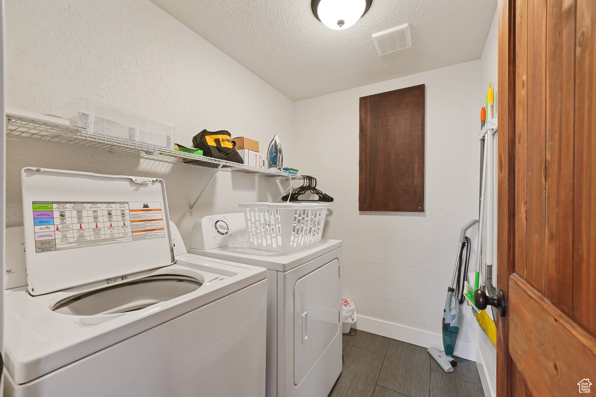 Laundry room featuring visible vents, baseboards, laundry area, a textured ceiling, and washing machine and dryer