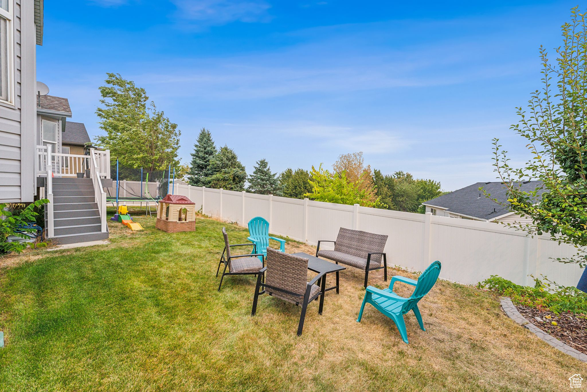 View of yard with a trampoline and a fenced backyard