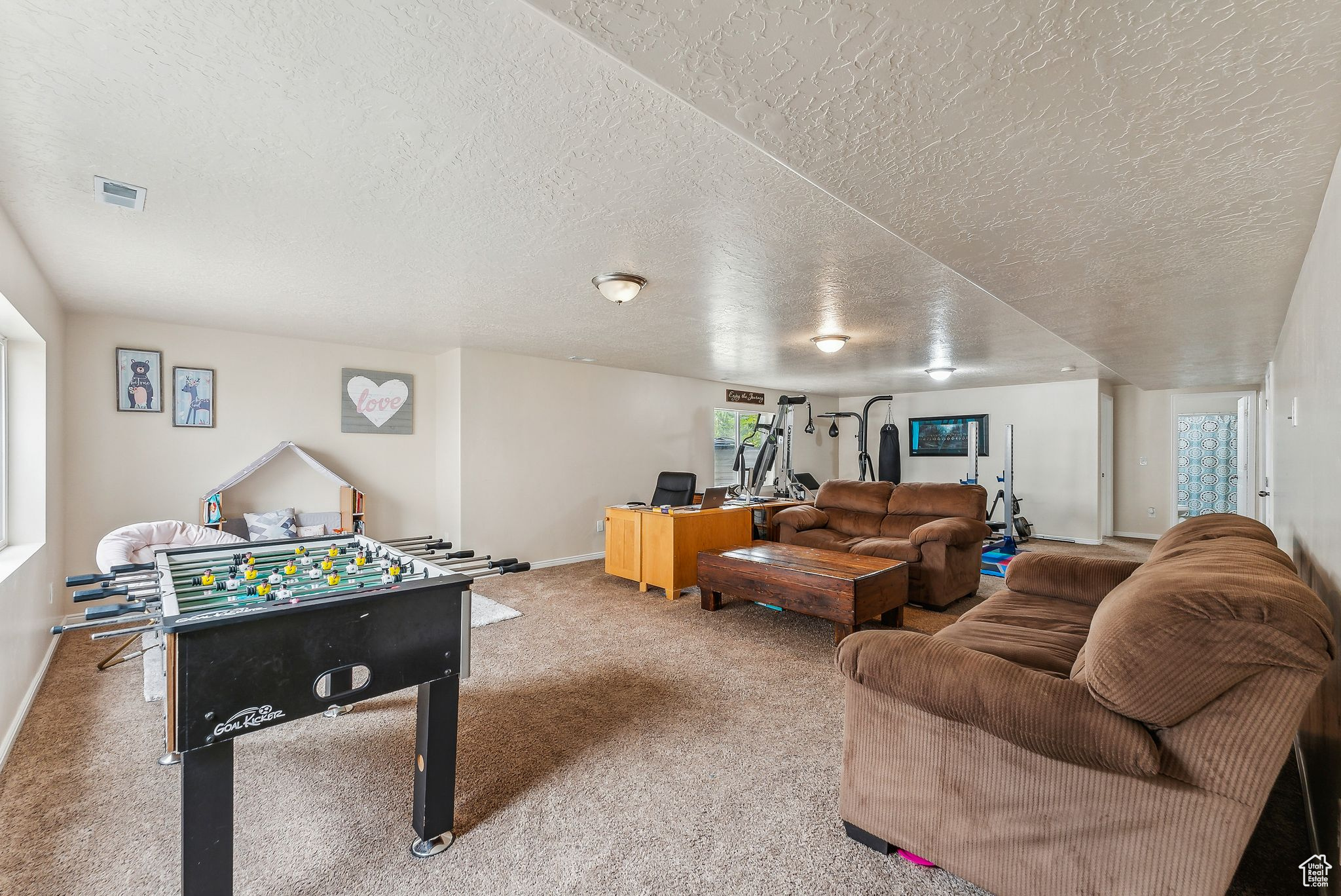 Playroom with visible vents, a textured ceiling, baseboards, and carpet