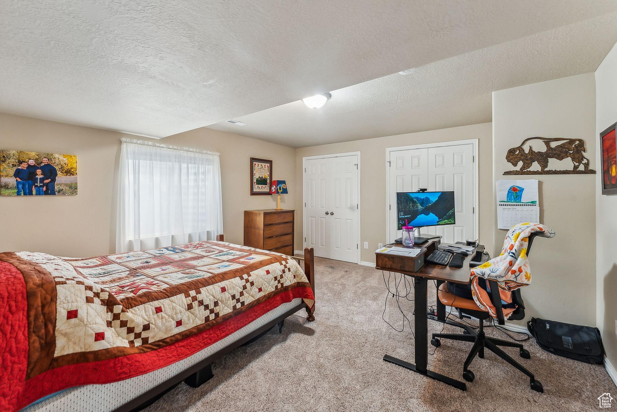 Bedroom featuring two closets, baseboards, a textured ceiling, and carpet flooring