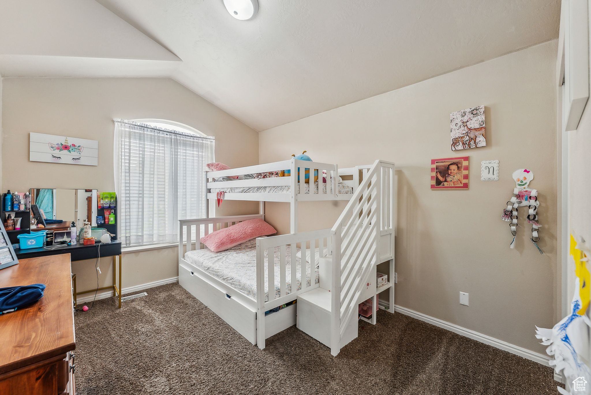 Bedroom with carpet flooring, baseboards, and lofted ceiling