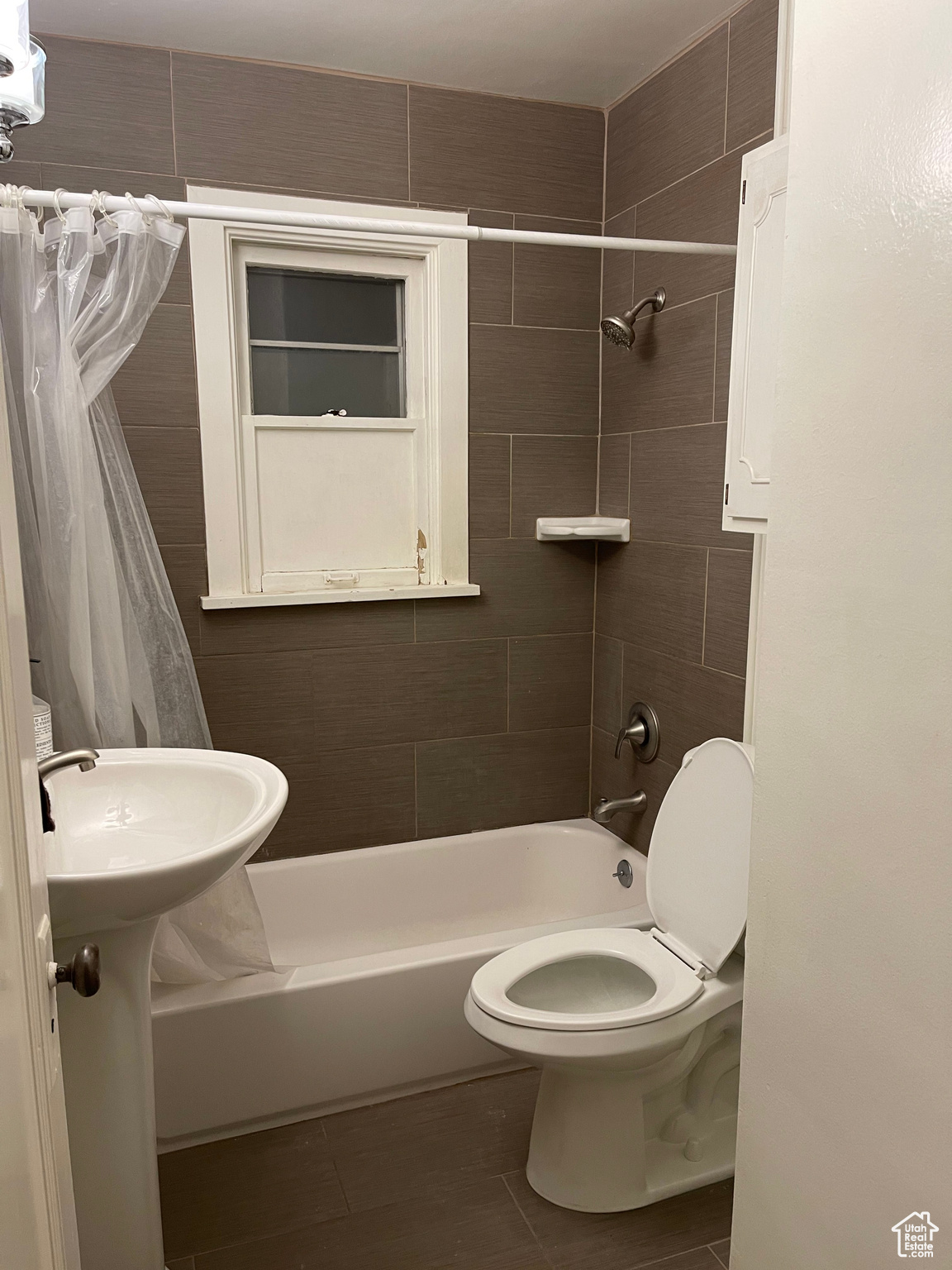 Bathroom featuring toilet and shower / tub combo with curtain