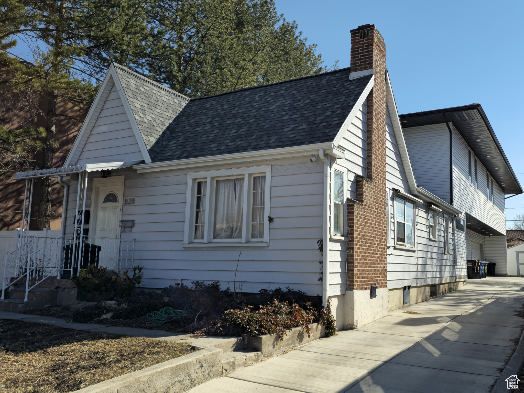 View of front facade featuring roof with shingles and a chimney