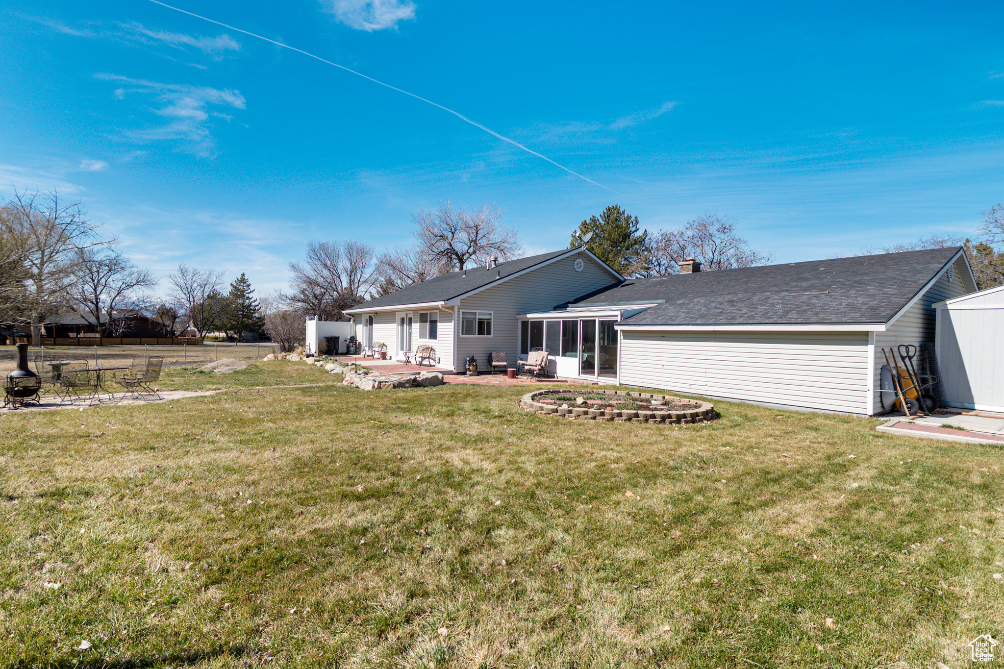 Rear view of house featuring sunroom and a patio area