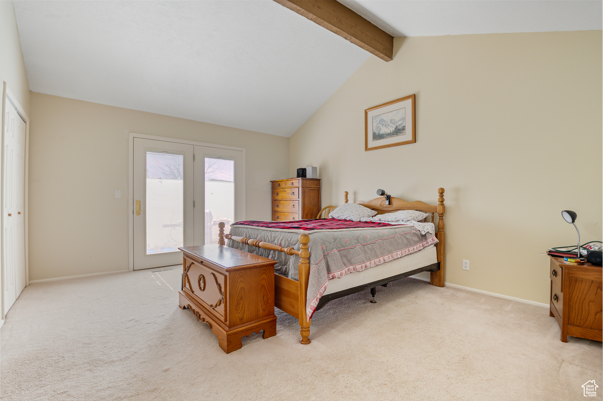 Primary Bedroom with french doors to back yard, vaulted ceiling with beam