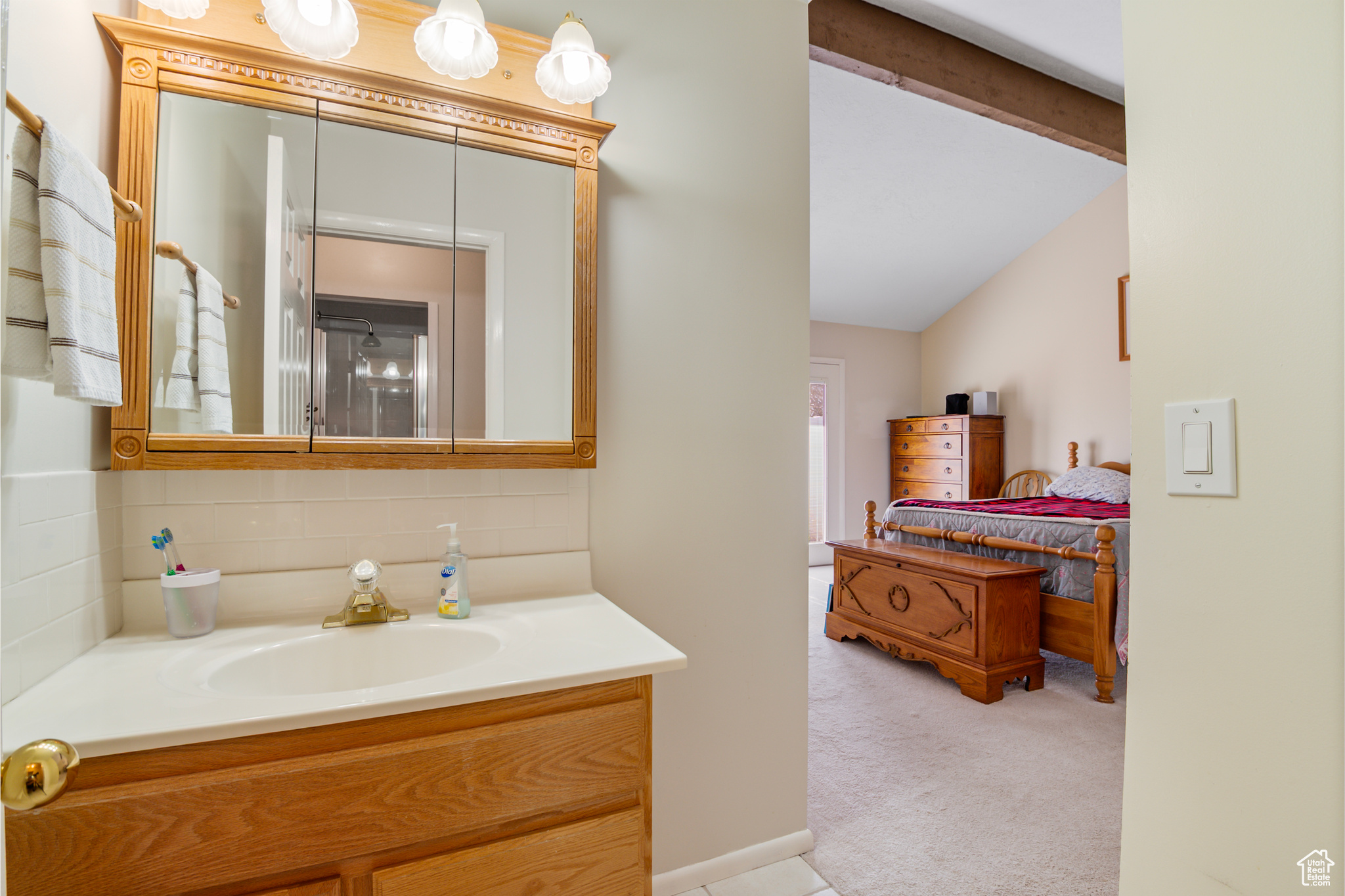 Primary Bedroom Suite with Bathroom with vanity, vaulted ceiling with beam