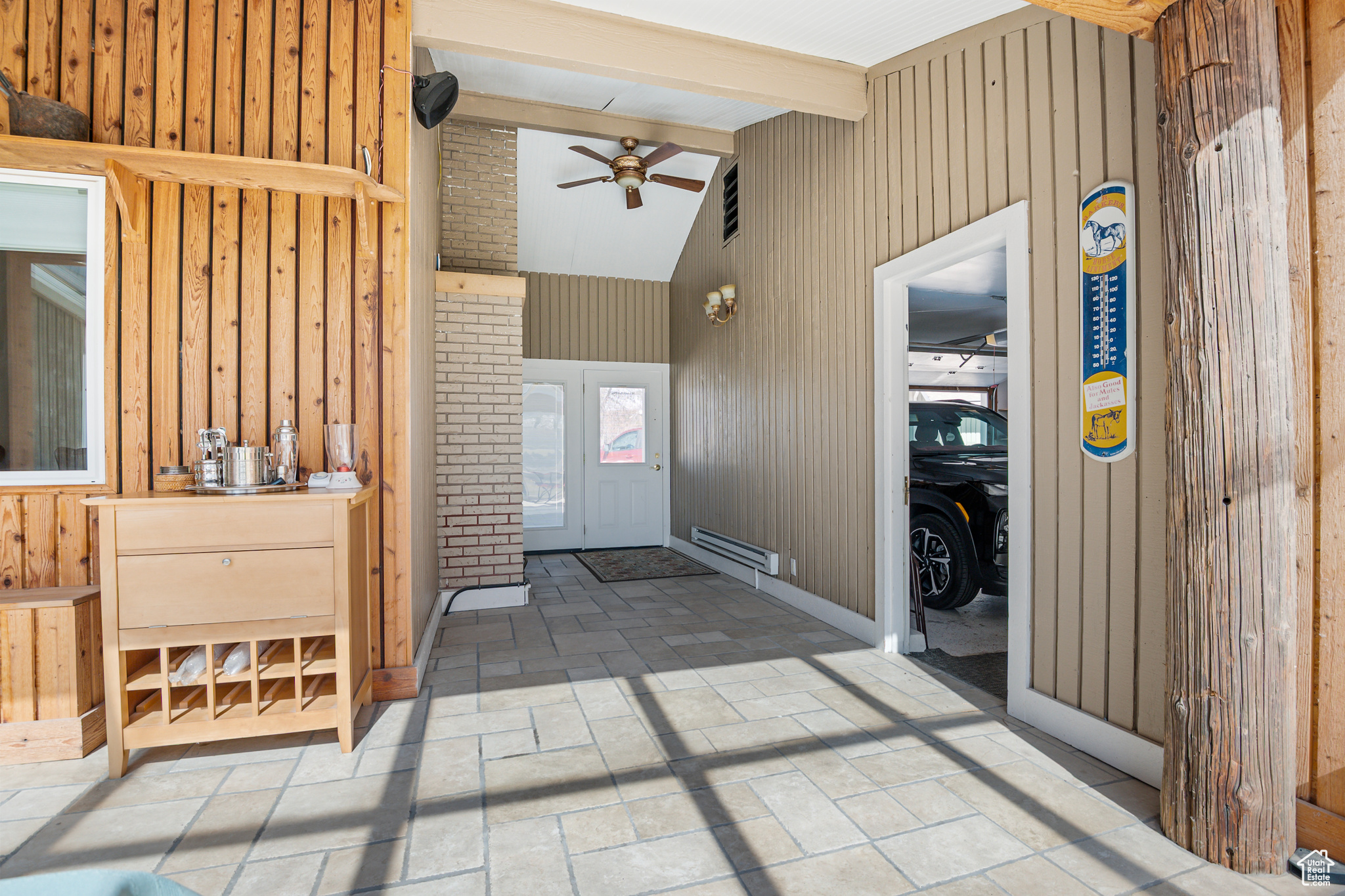 Foyer entrance featuring wooden walls, vaulted ceiling
