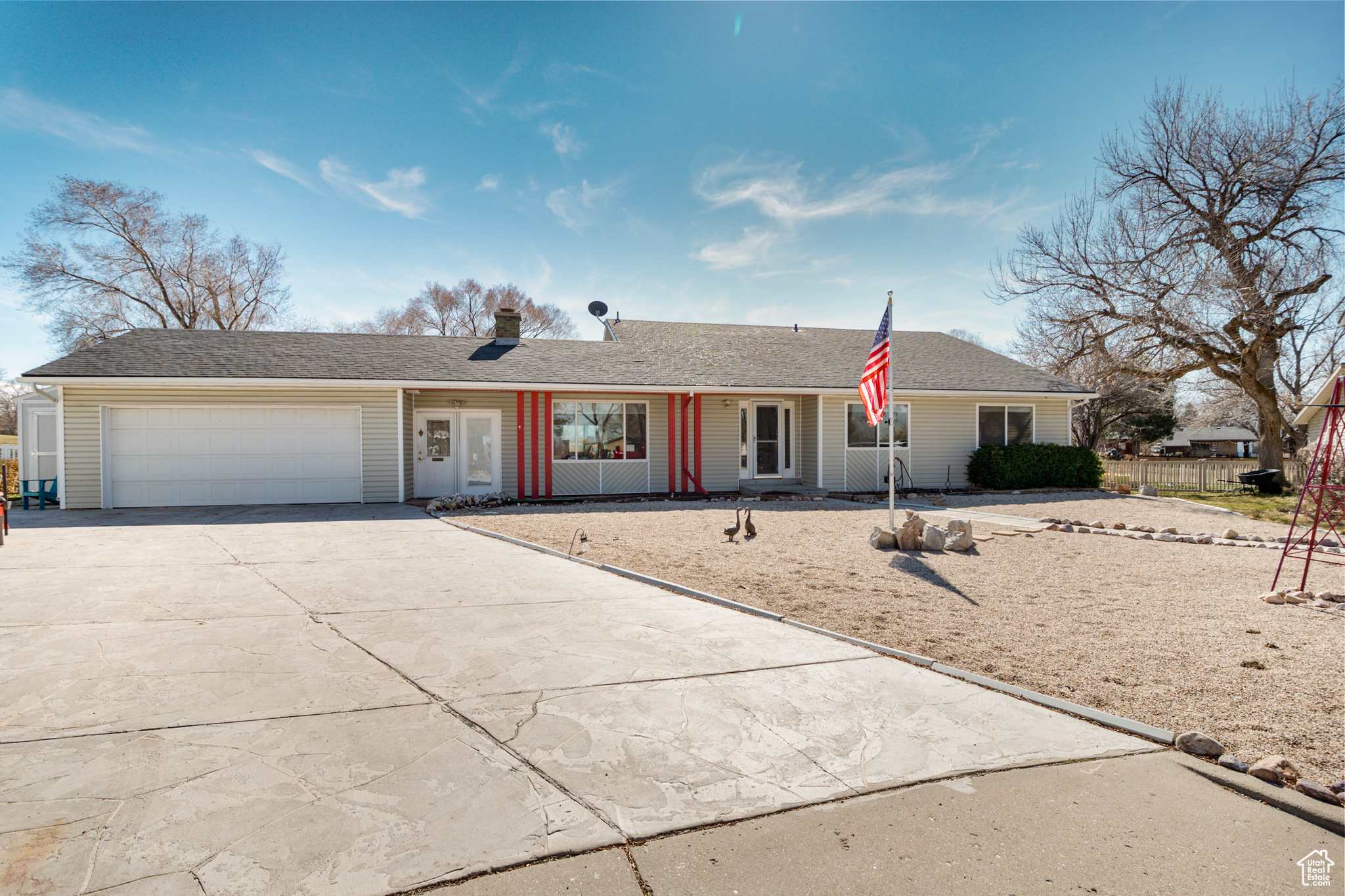 Ranch-style house featuring attached double garage, concrete driveway and xeriscaped yard