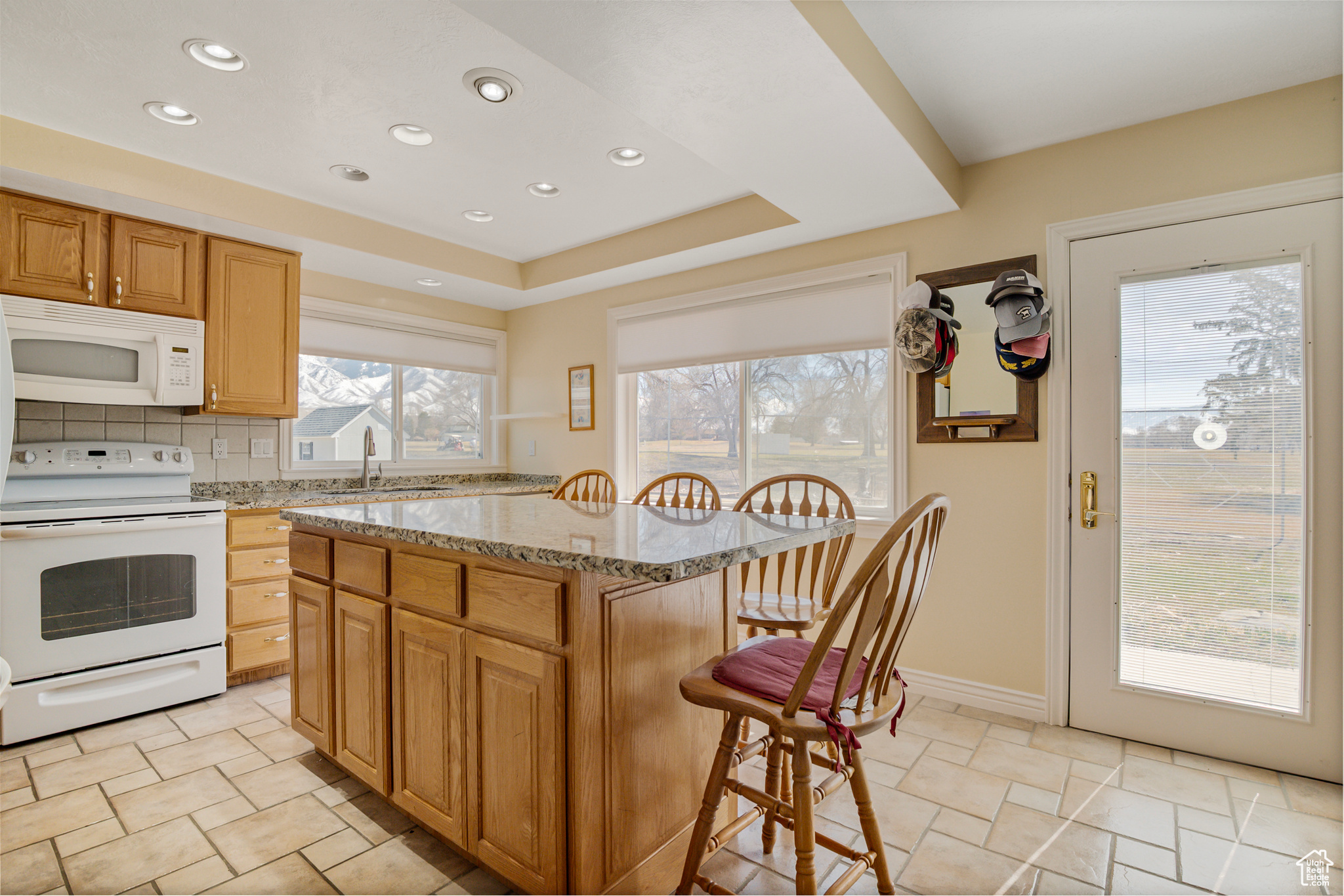 Kitchen featuring light stone countertops, breakfast bar and tasteful backsplash