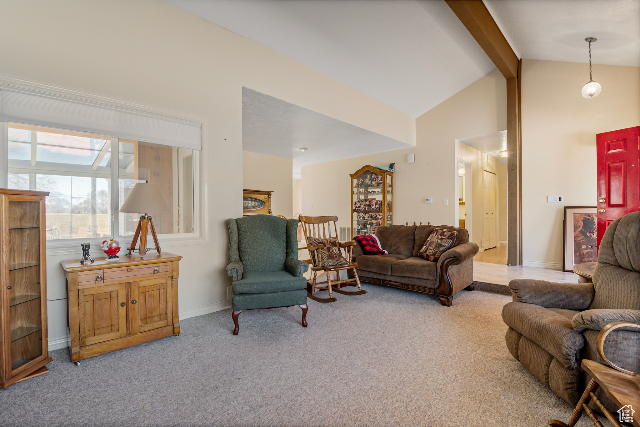 Carpeted living room with lofted ceiling with beams and baseboards