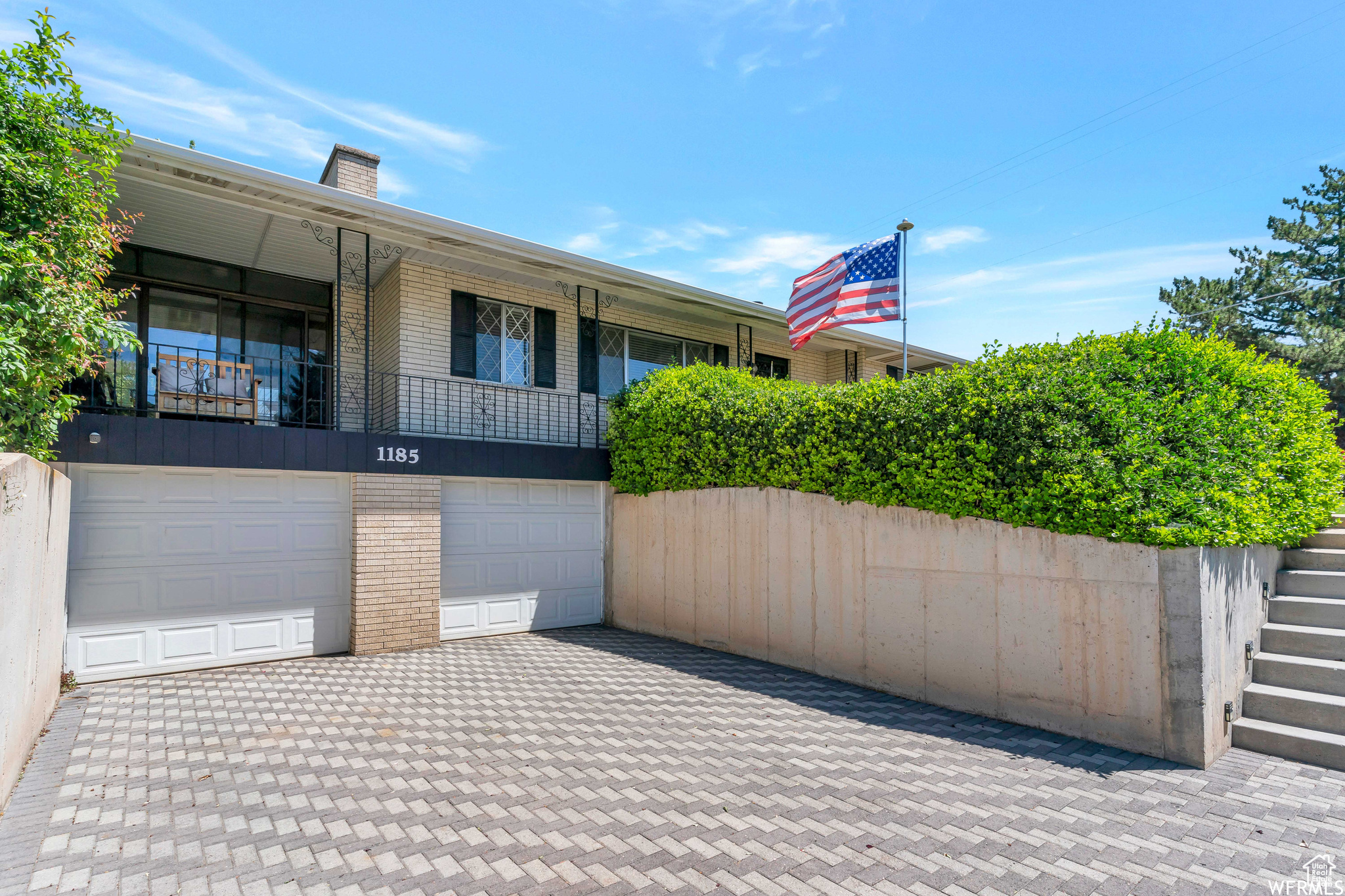 View of patio featuring driveway and a garage