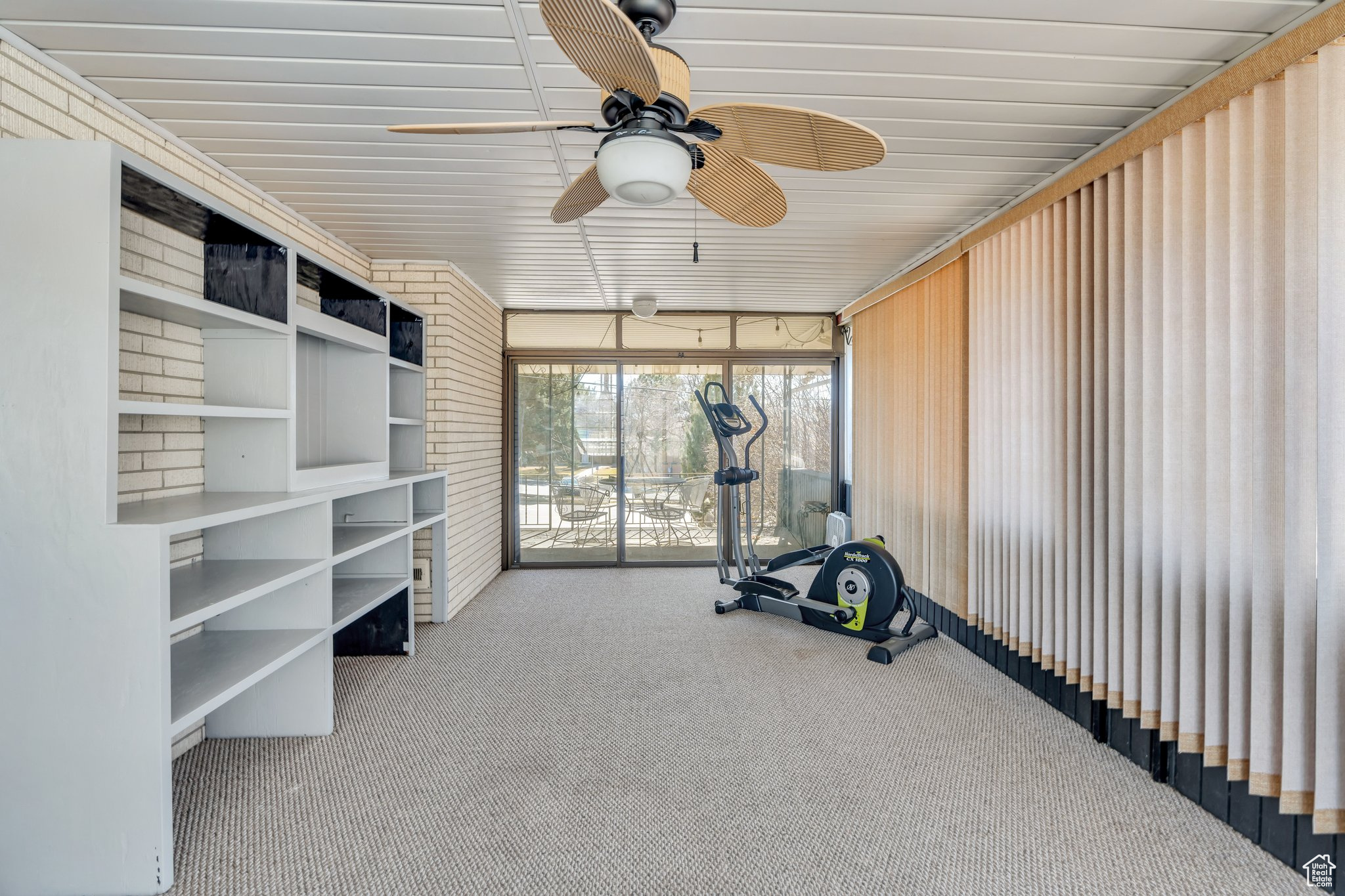 Exercise area with a ceiling fan and carpet floors