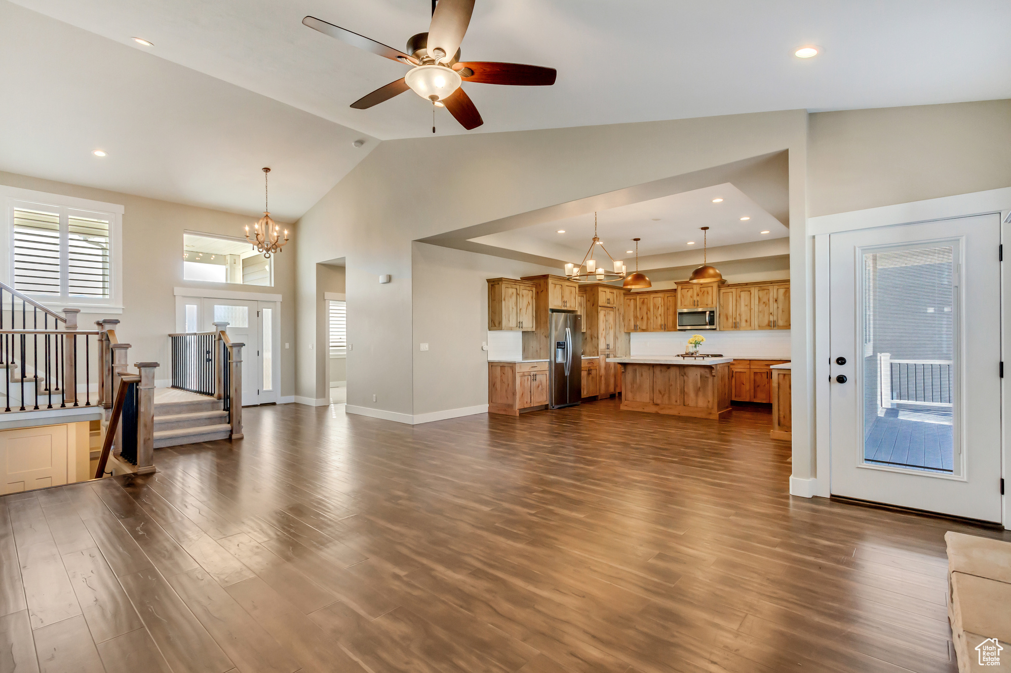 Unfurnished living room featuring wood floors, recessed lighting, stairs, and 5