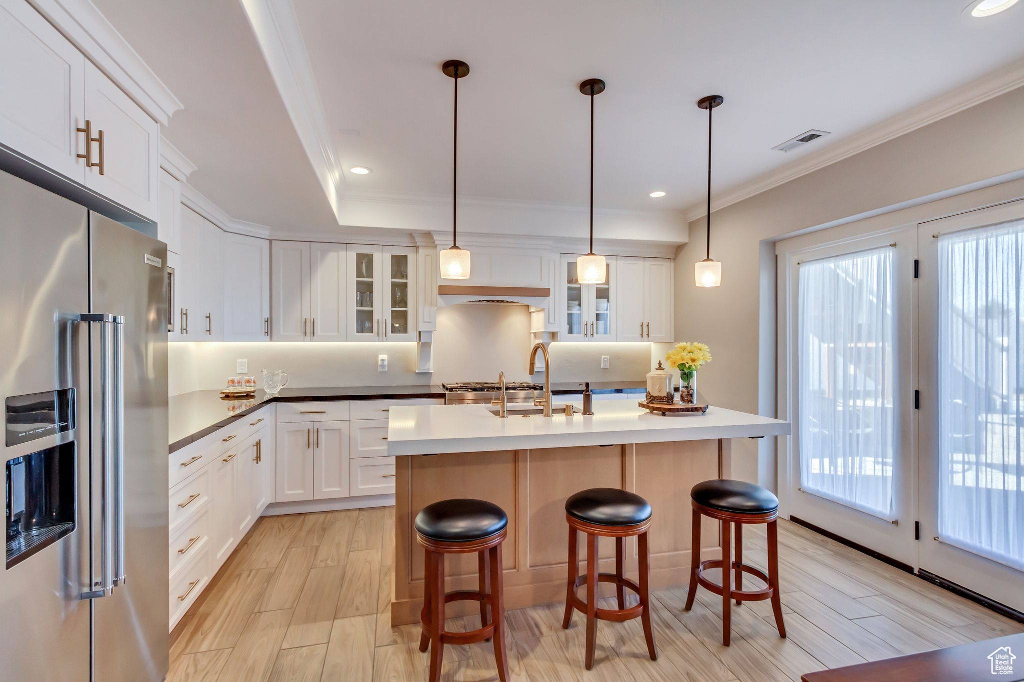 Downstairs In-law suite Kitchen with a wealth of natural light, high end cabinetry, and light wood-style tile floor.