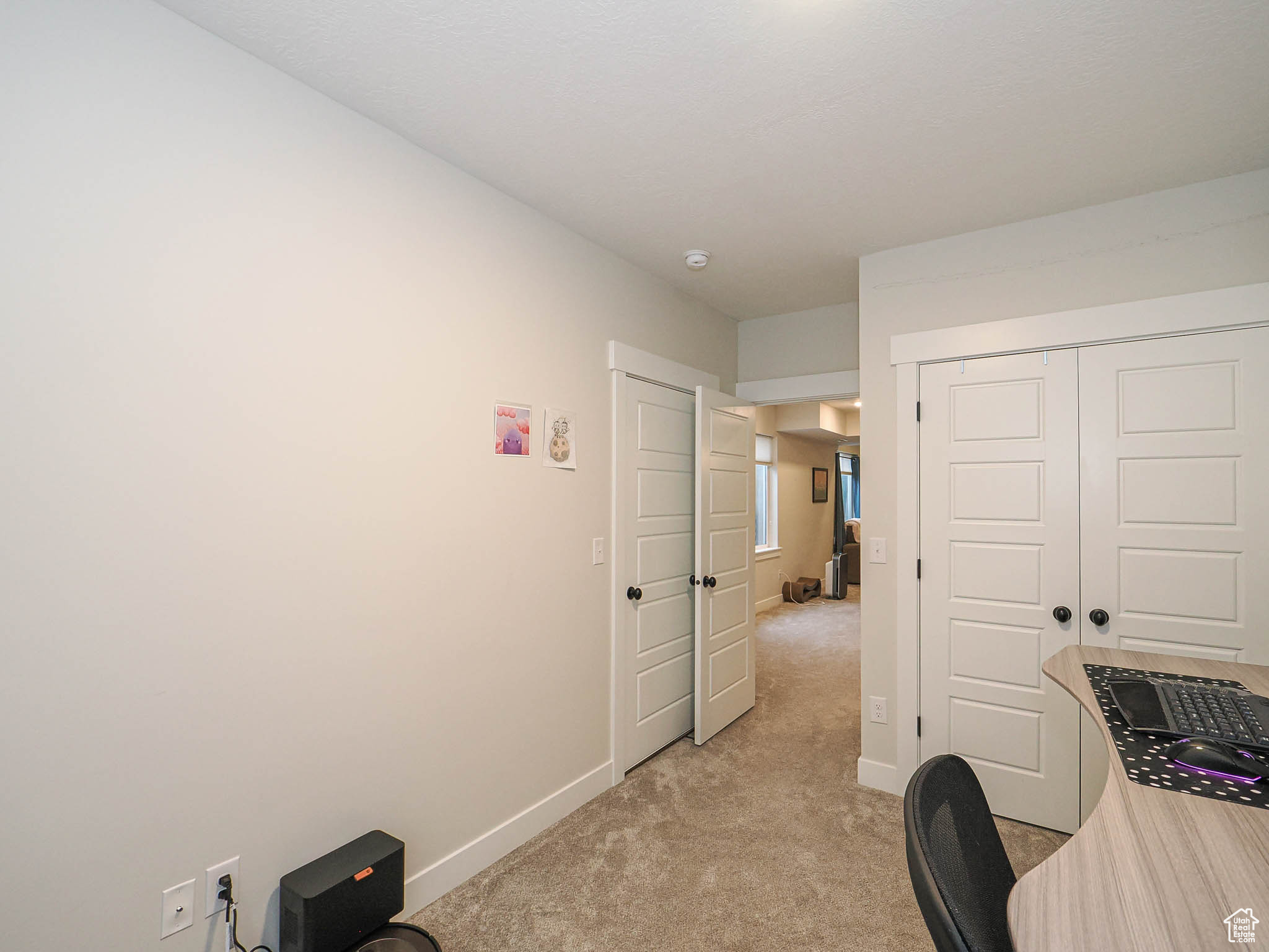 Office area with light colored carpet and baseboards
