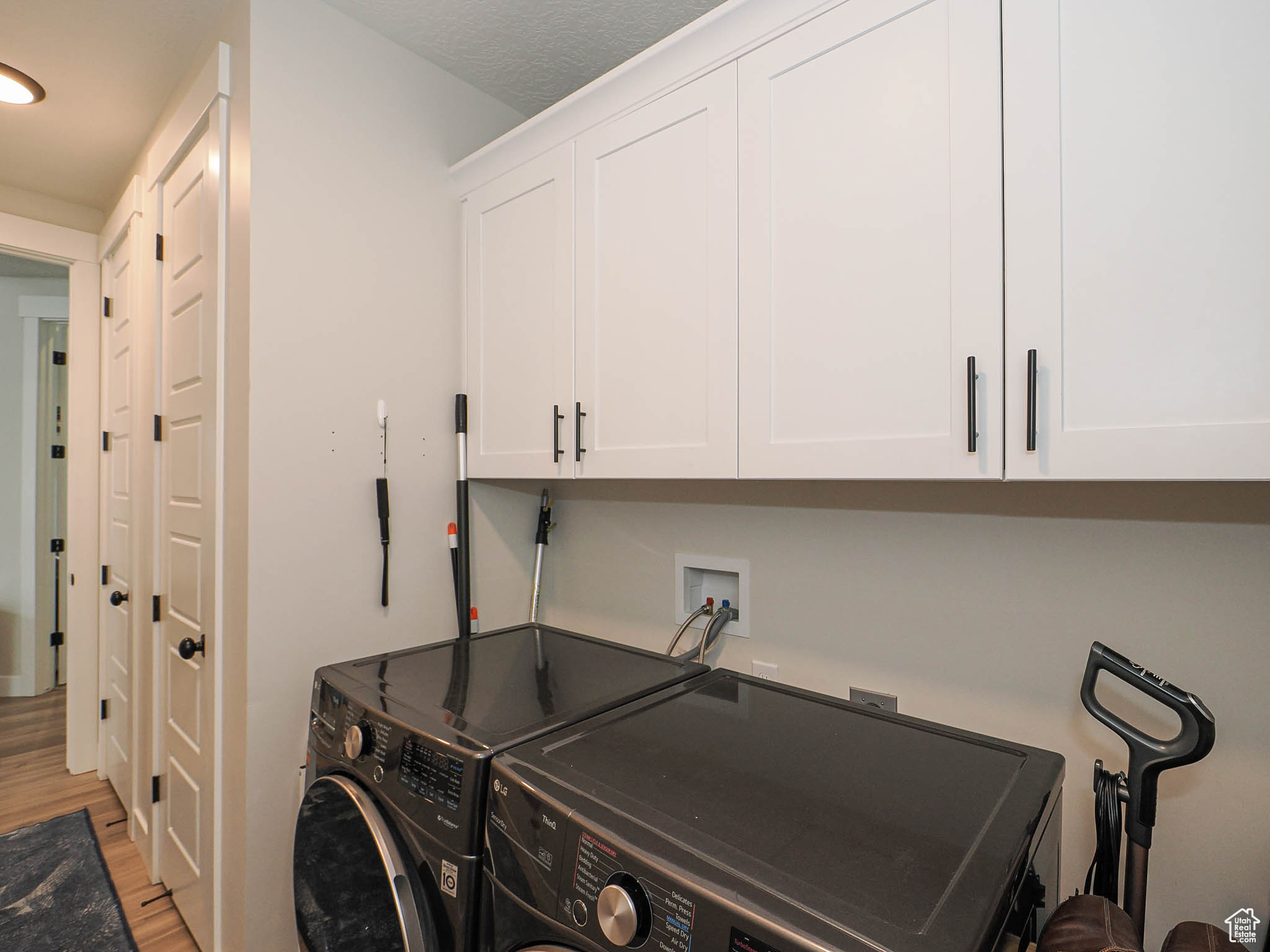 Washroom with cabinet space, light wood-style flooring, and separate washer and dryer