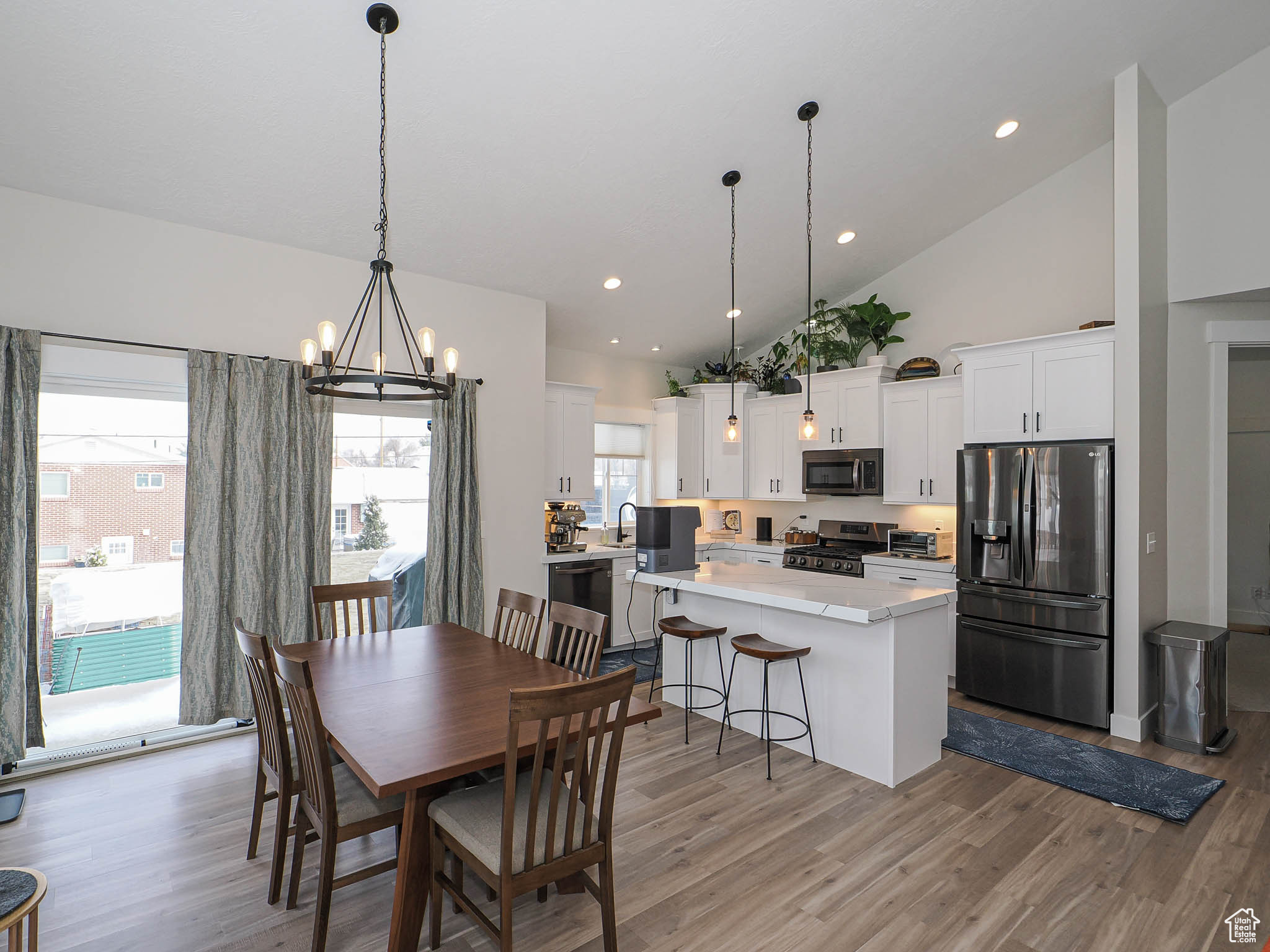 Dining room featuring light wood-style flooring, high vaulted ceiling, a chandelier, and recessed lighting