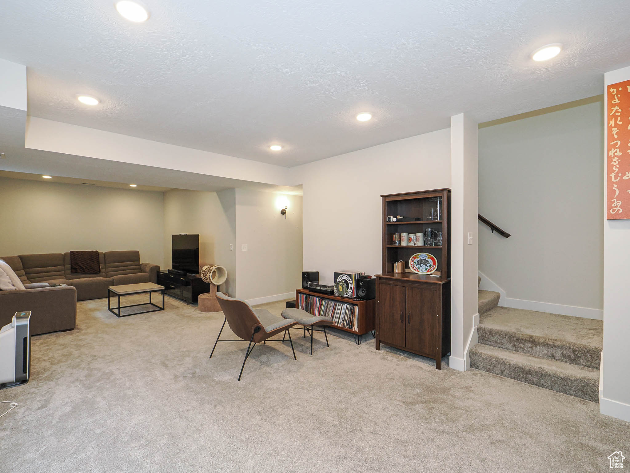 Living room with light carpet, stairway, baseboards, and recessed lighting