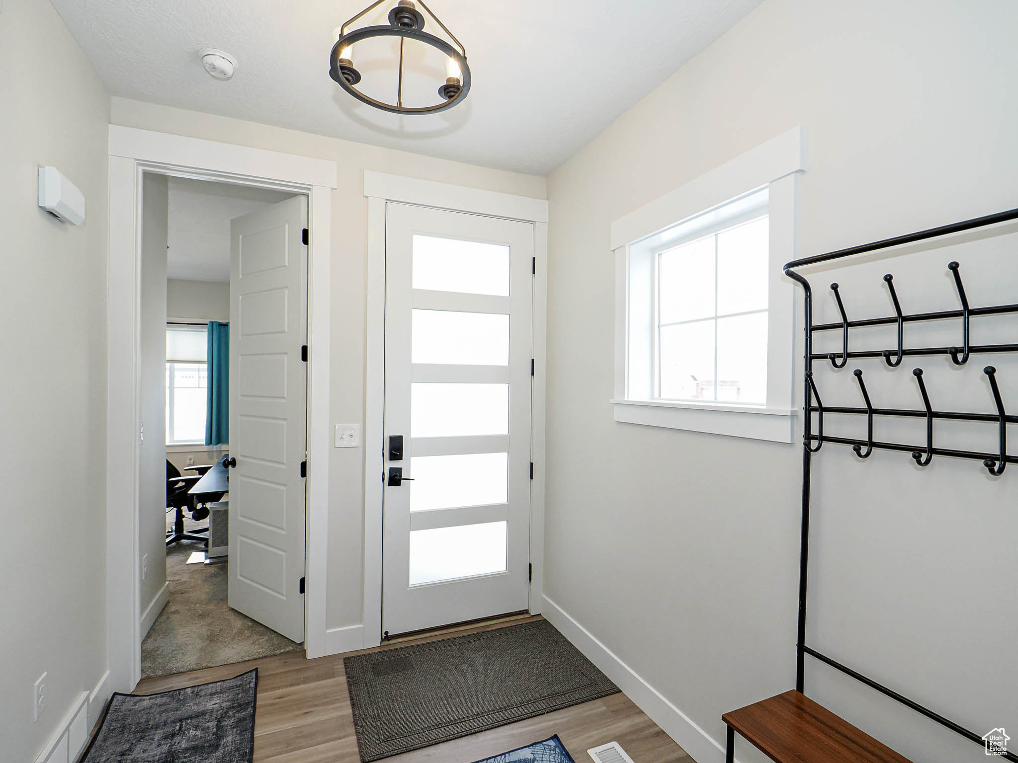 Foyer entrance featuring light wood-type flooring, baseboards, and a wealth of natural light