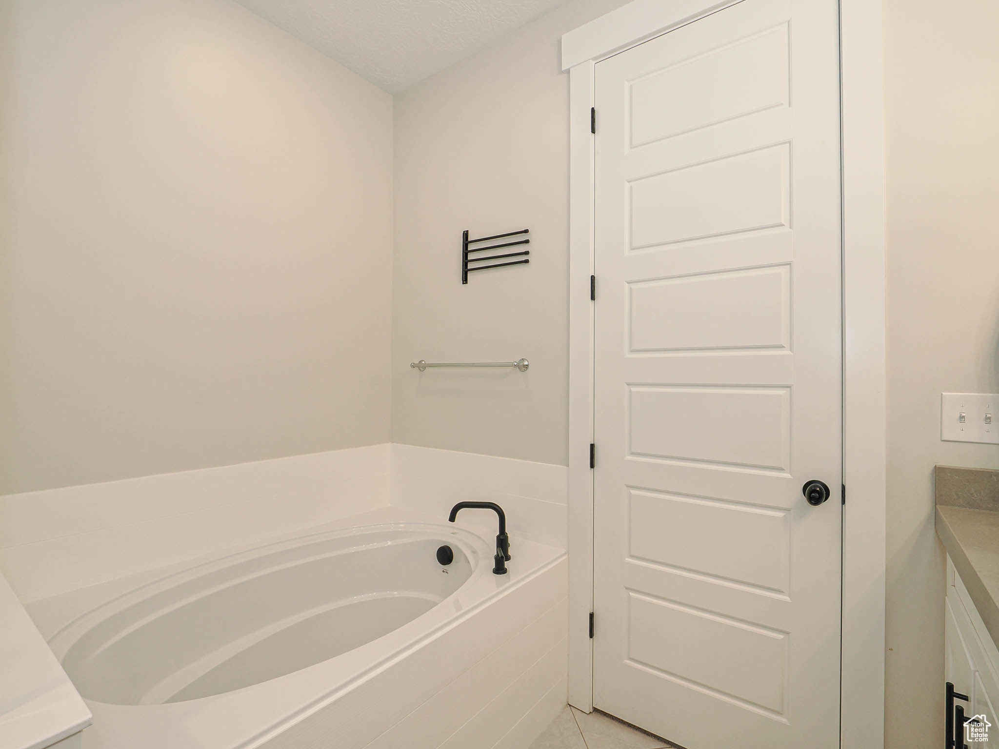Bathroom featuring a garden tub, vanity, and tile patterned floors